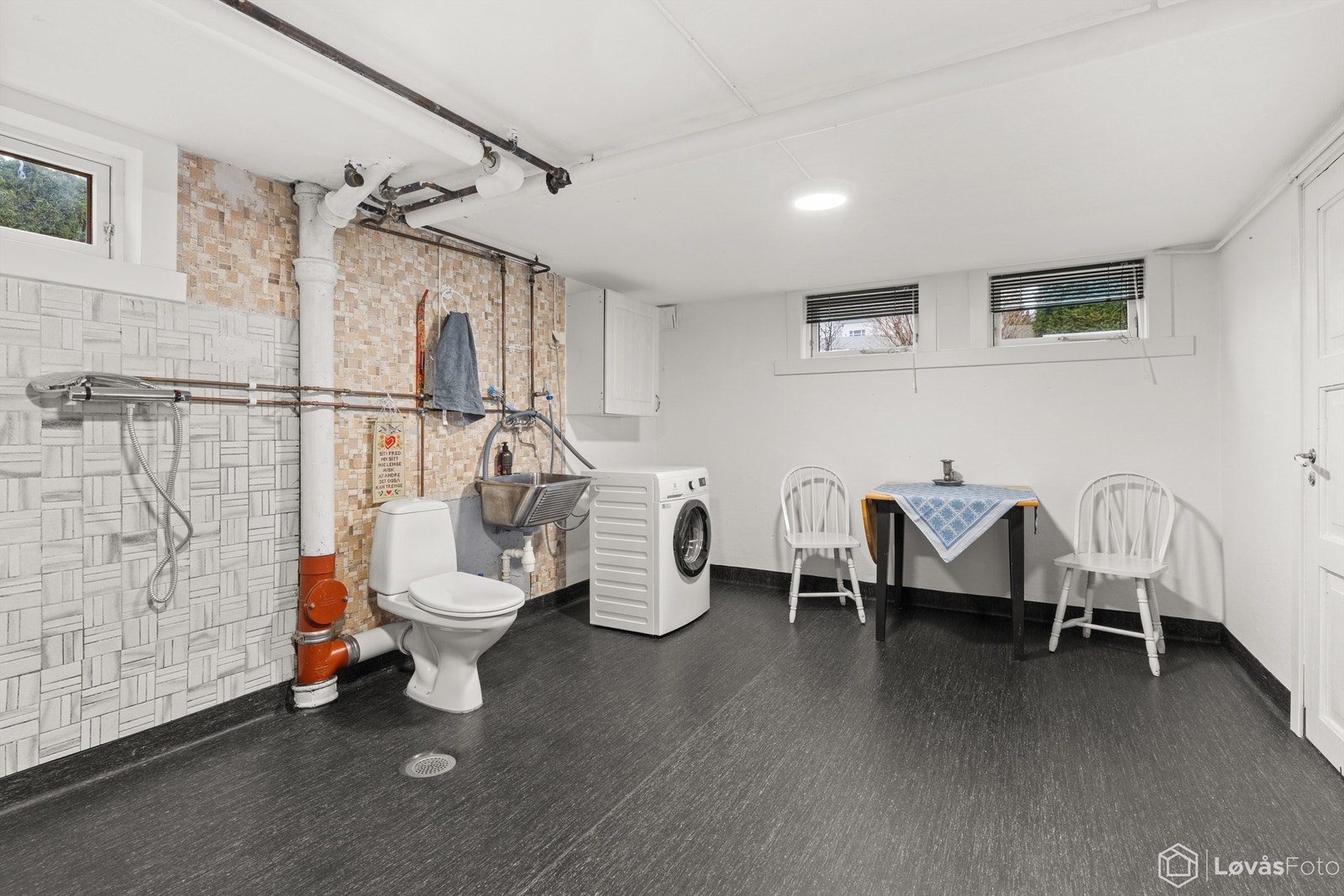 Stort vaskerom belagt med gulvbelegg (fra 2019), vegger med malt tapet og fliser, samt malte himlingsflater. Galleribilde