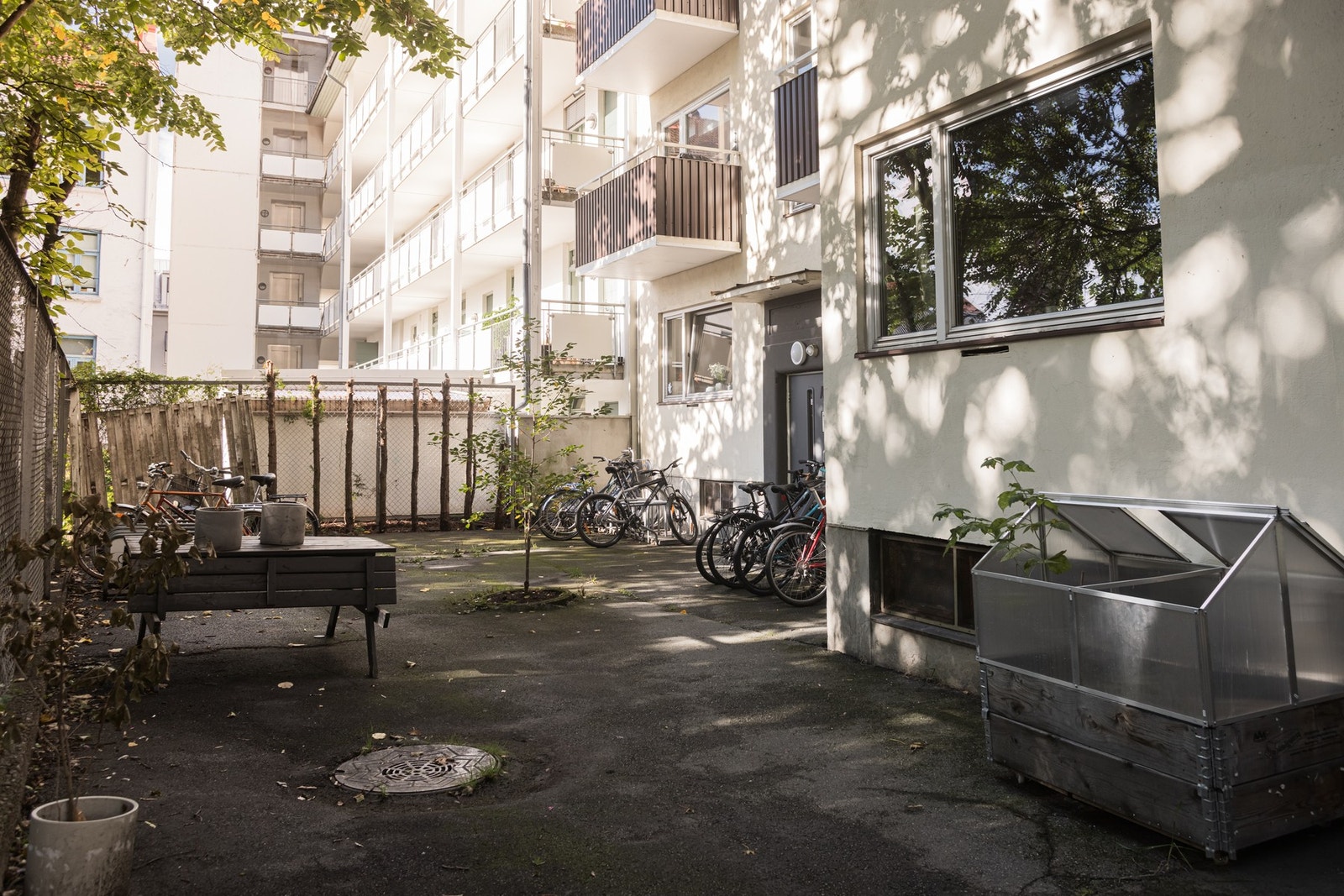Inngjerdet bakgård med bl.a. benk og sykkelparkering. Galleribilde
