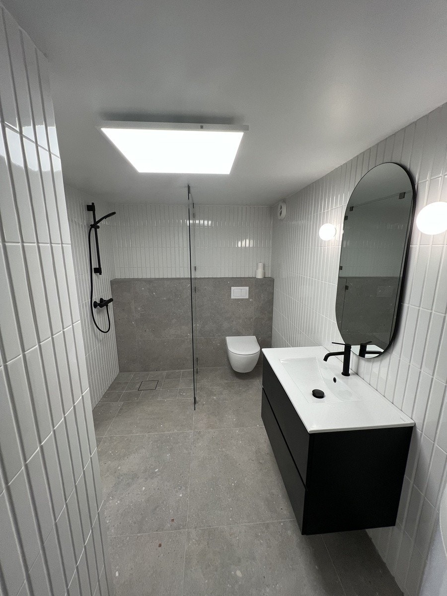 Helfliset bad med lekre sorte detaljer Galleribilde