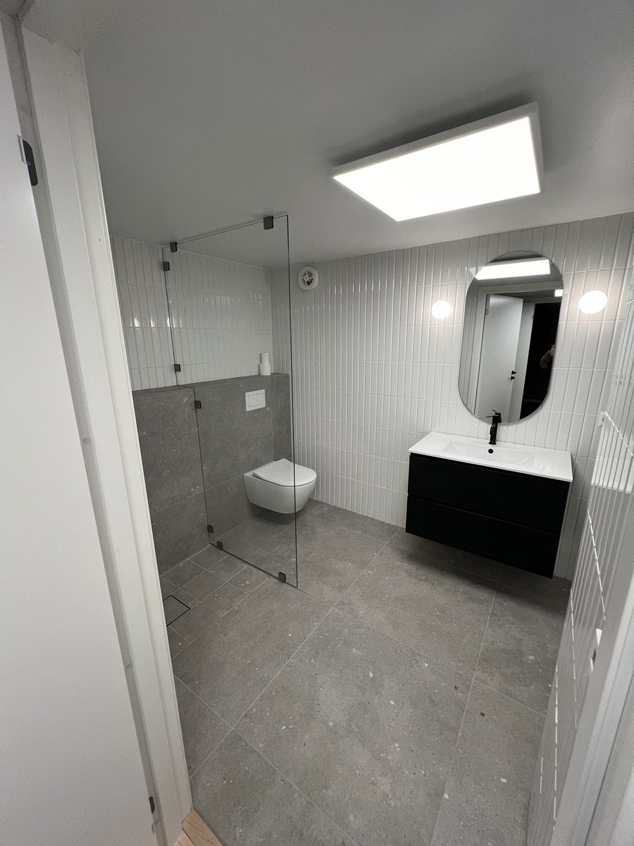 Helfliset bad med lekre sorte detaljer Galleribilde