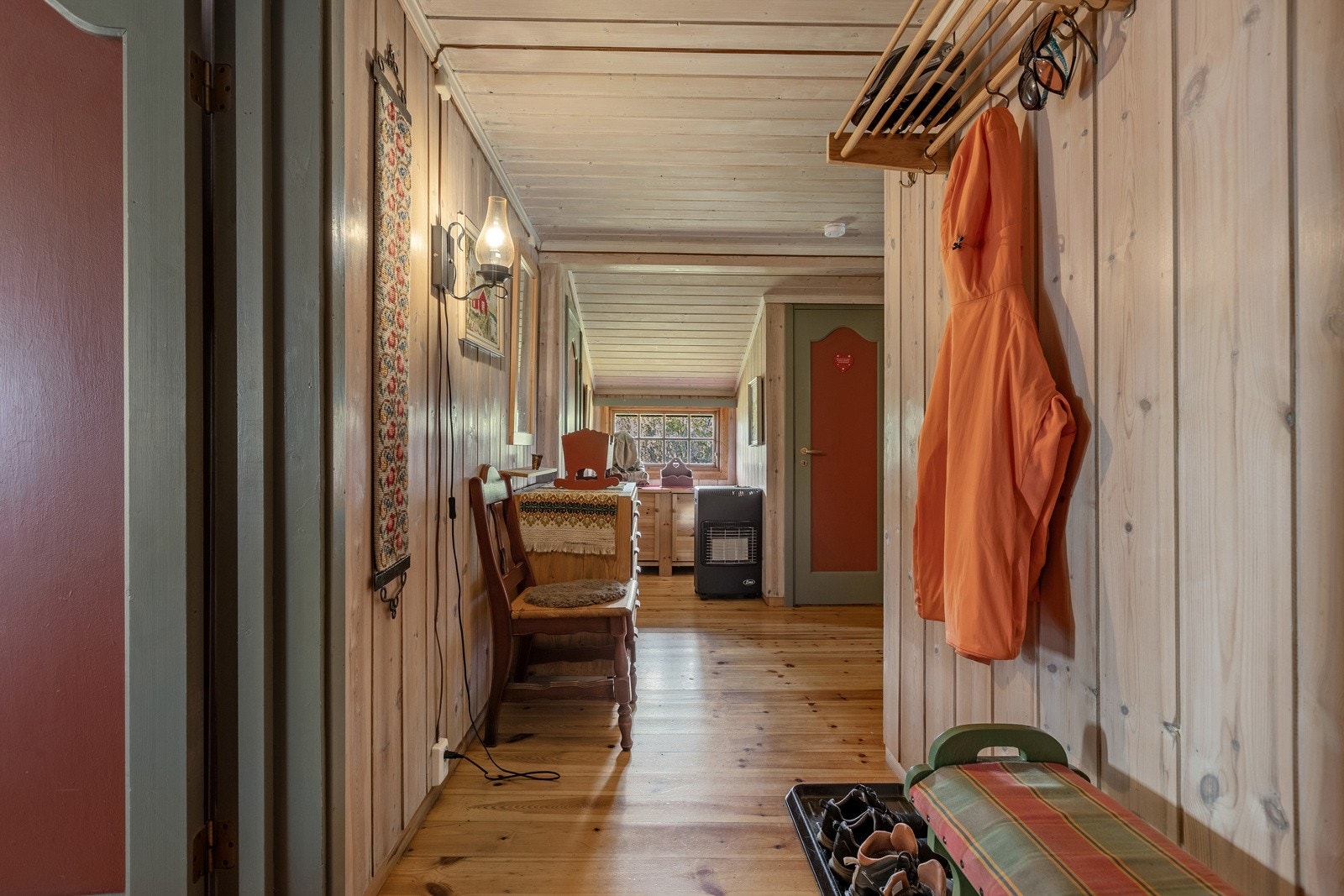 Hytta har hovedsaklig panel på vegg, plater i himling og lakkerte tregulv Galleribilde