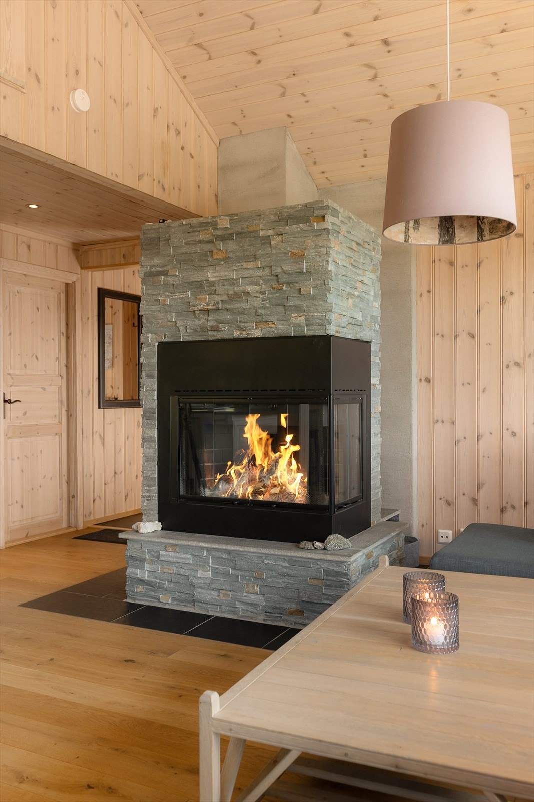 En flott muret peis blir et naturlig blikkfang i rommet. Peisen kan enkelt gjøres om til en åpen peis og gir god varme og skaper hyggelig stemning. Galleribilde