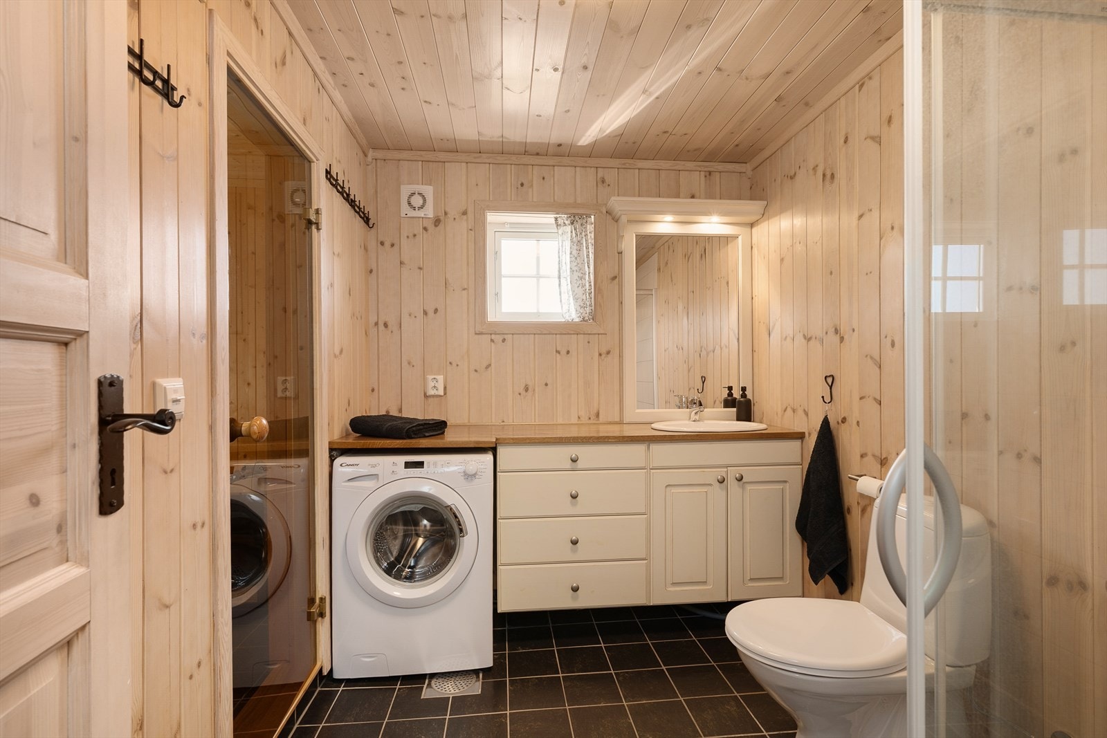 Hovedbadet har servantinnredning i tre, dusj, gulvmontert WC samt direkte adkomst til badstue. Opplegg for vaskemaskin. Galleribilde