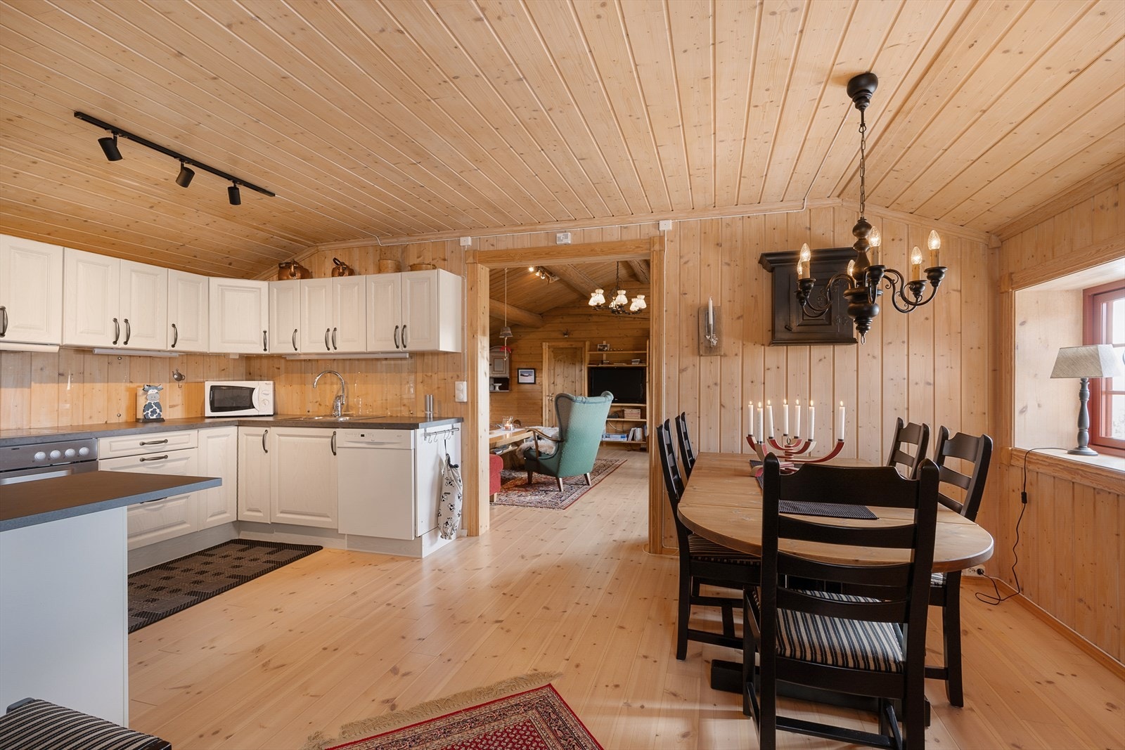 Det romslige kjøkkenet har hvit innredning med lett profilering. Rikelig med både skap-og benkeplass. Galleribilde