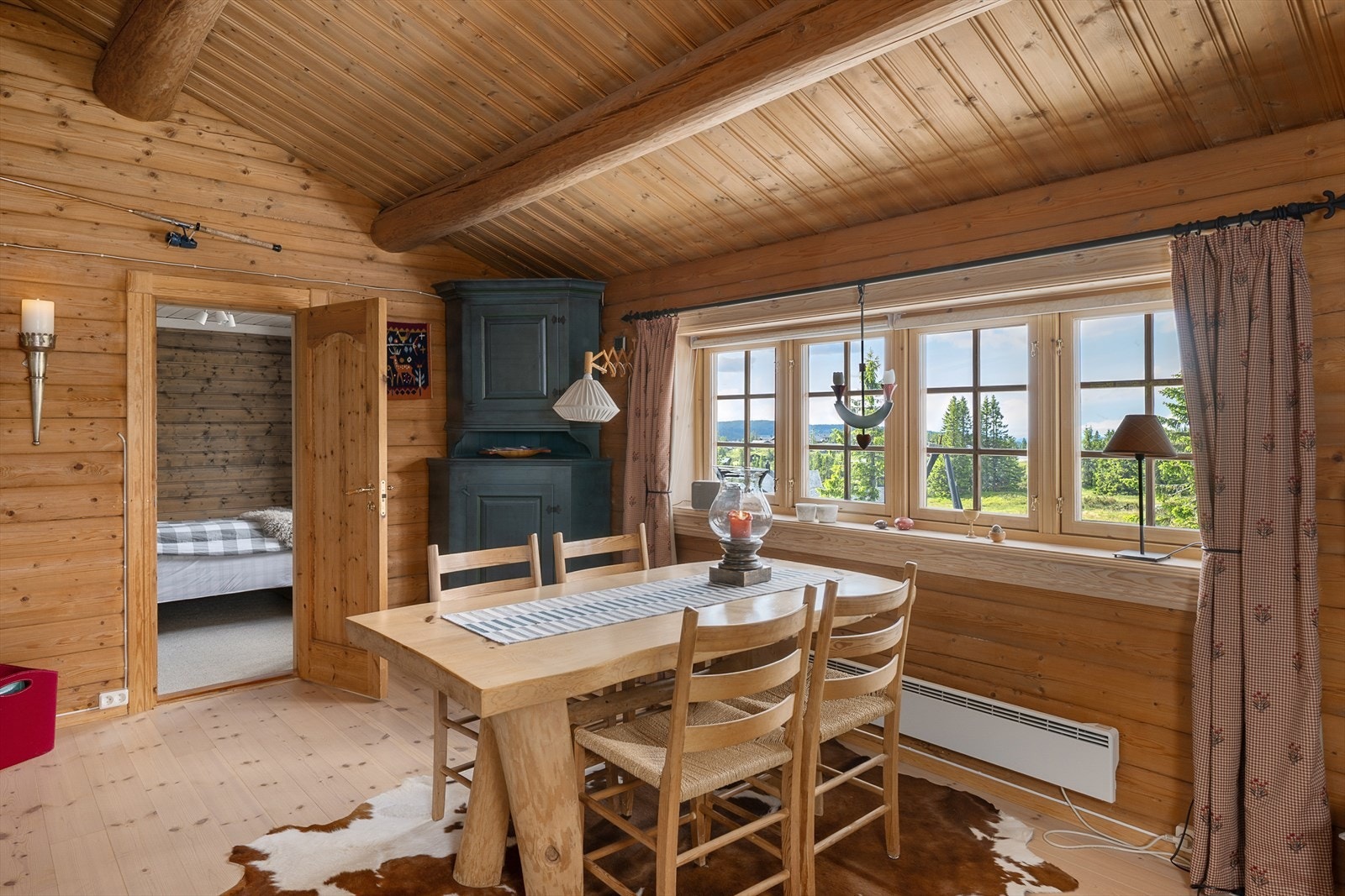 Hyggelig spiseplass ved vinduet. Fra stua er det adkomst til 2 av soverommene i hytta. Galleribilde