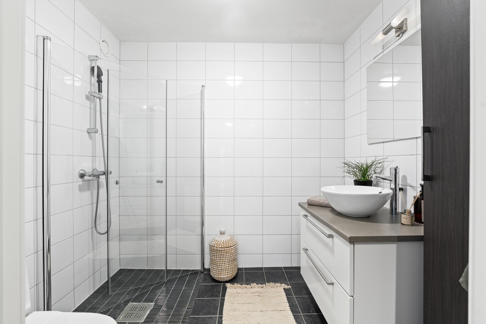 Bad 1.etg. Baderomsinnredning bestående av benkeskap med glatte fronter. Dusj med innfellbare dører i herdet glass, servant og klosett. Galleribilde