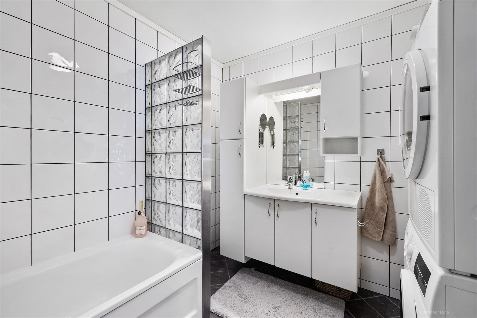 Det er glassbyggerstein som skille mellom badekar og servant, fliser på gulv og vegger med varme i gulvet. Galleribilde