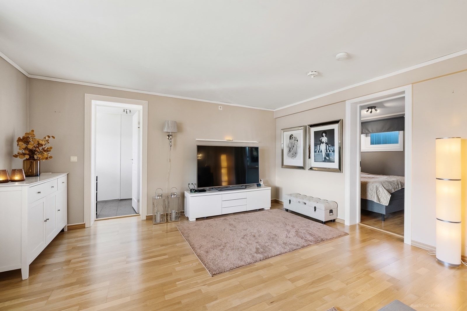 Romslig stue med lyse malte vegger og parkett på gulv. Galleribilde