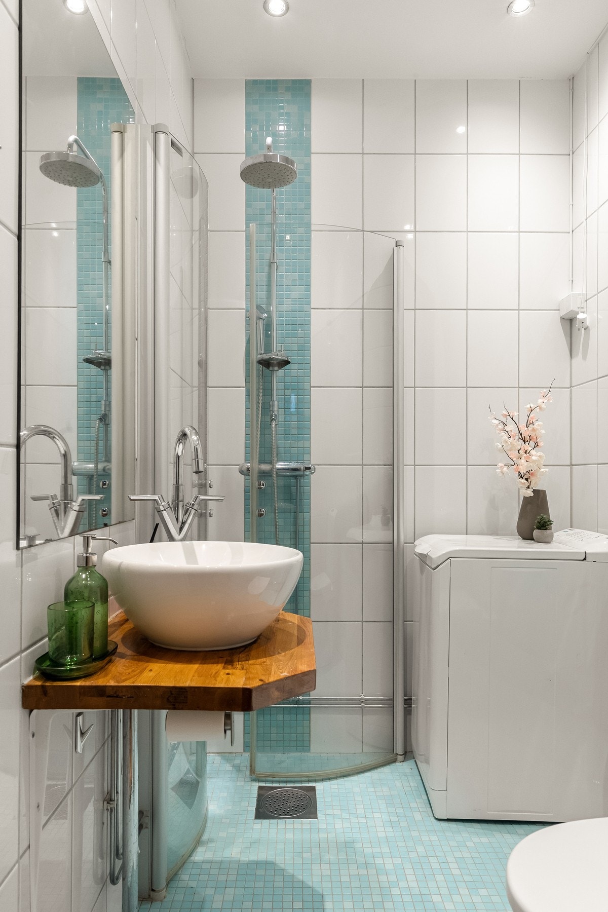 De hvite flisene gir rommet et rent og klassisk uttrykk, mens mosaikkflisene tilfører et fargespill. Galleribilde