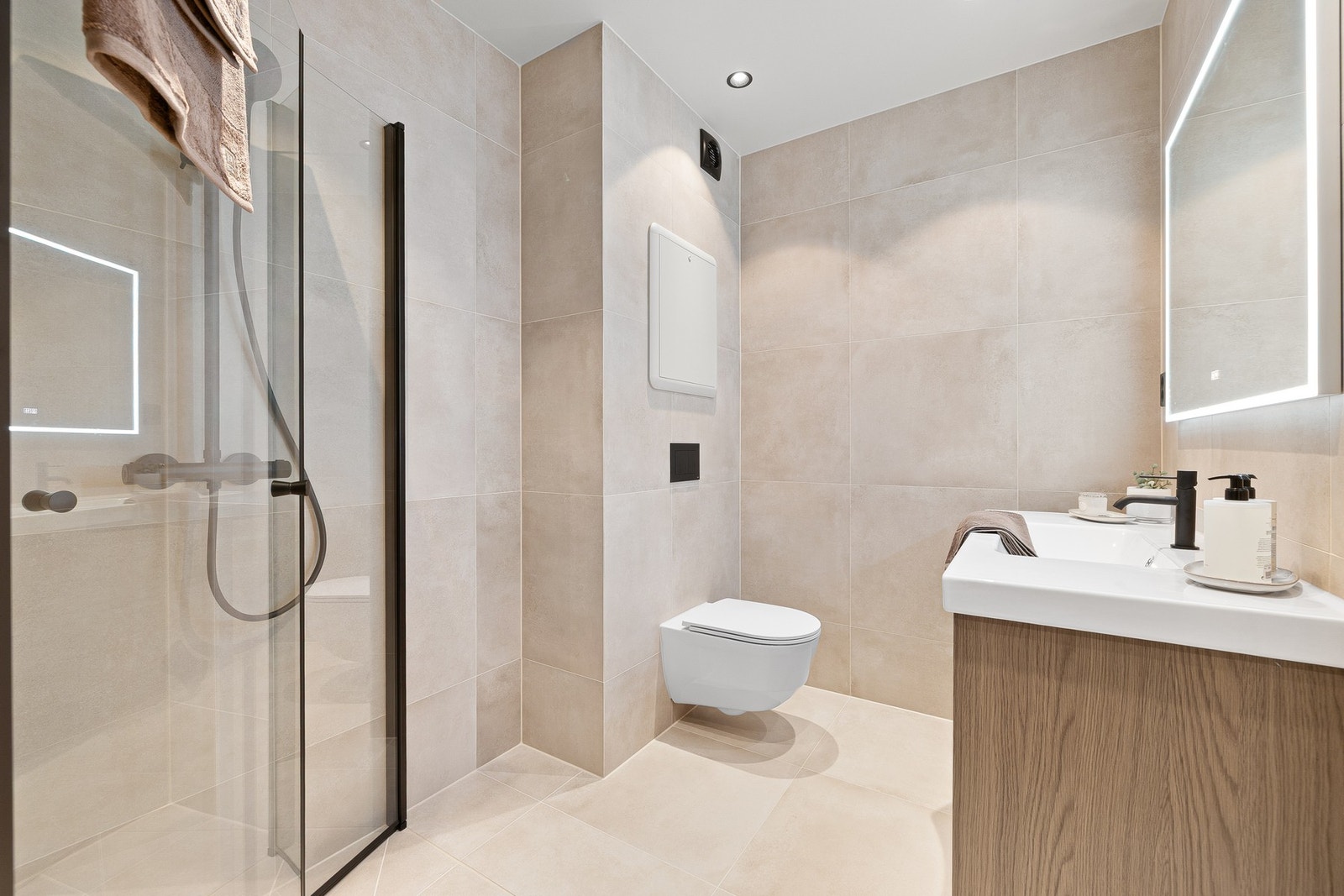 Badet er innredet med dusjnisje, vegghengt toalett og servant med underskap og speil. Galleribilde