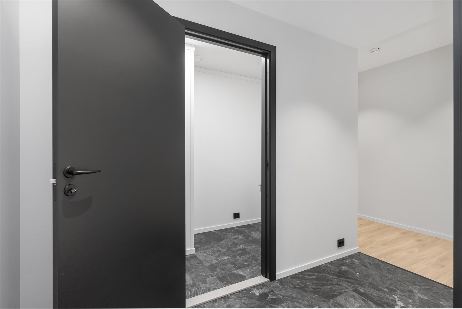 Inngangsparti med flislagt gulv. Rett ved er det en bod. Galleribilde