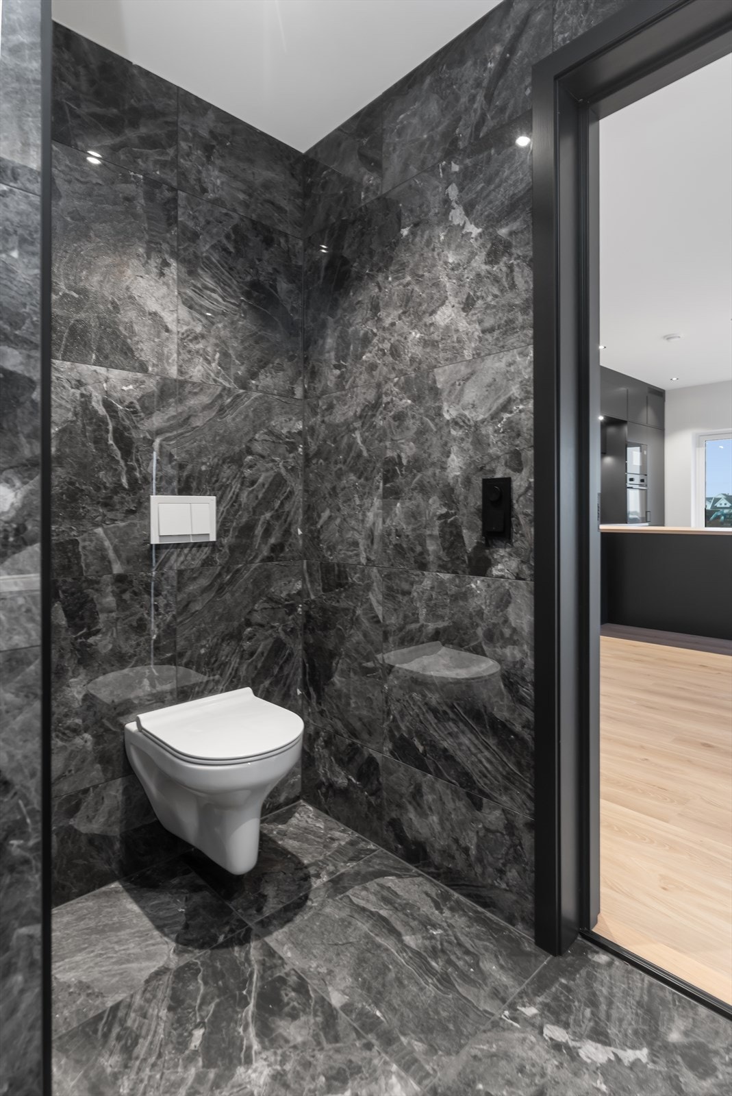 Vegghengt toalett, servant og dusj på gulv. Galleribilde