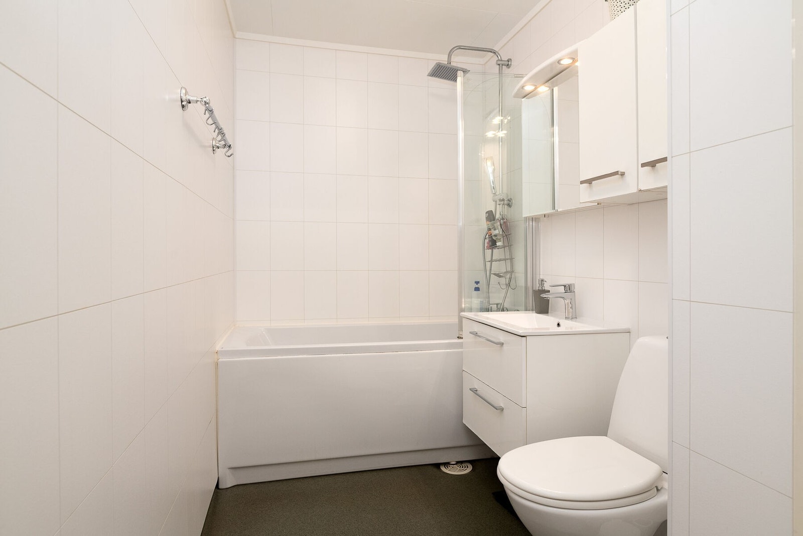 Baderom fra byggeår som ble fornyet i 2013. Det er servant på skuffeseksjon, speilskap med lys, toalett og badekar/dusj. Varmekabler i gulv. Galleribilde