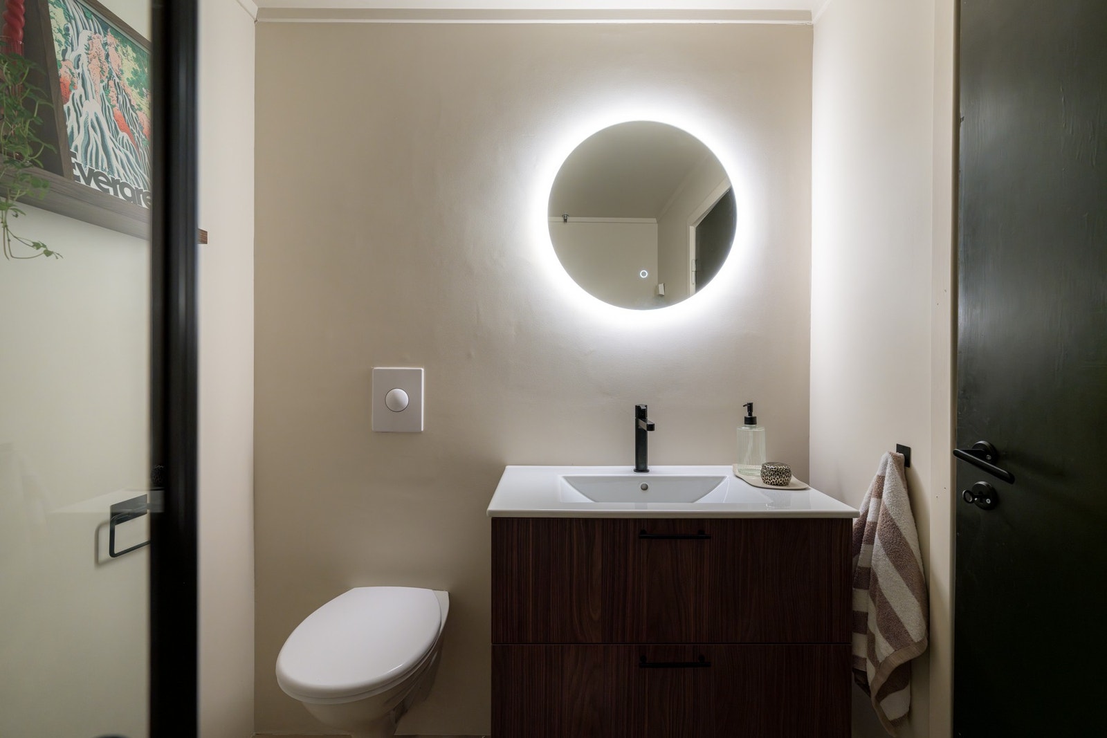 Badet er utstyrt med vegghengt servantskap med skuffer og ovenpåliggende servant med ett-greps armatur. Galleribilde