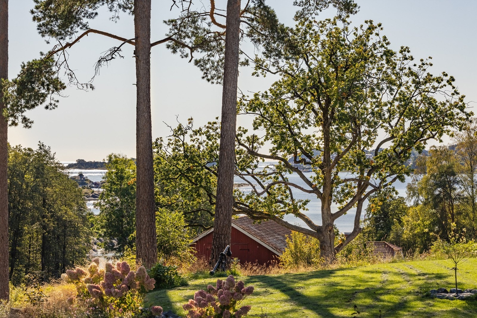 Fra eiendommen er det glimt av sjøen gjennom trærne. Galleribilde
