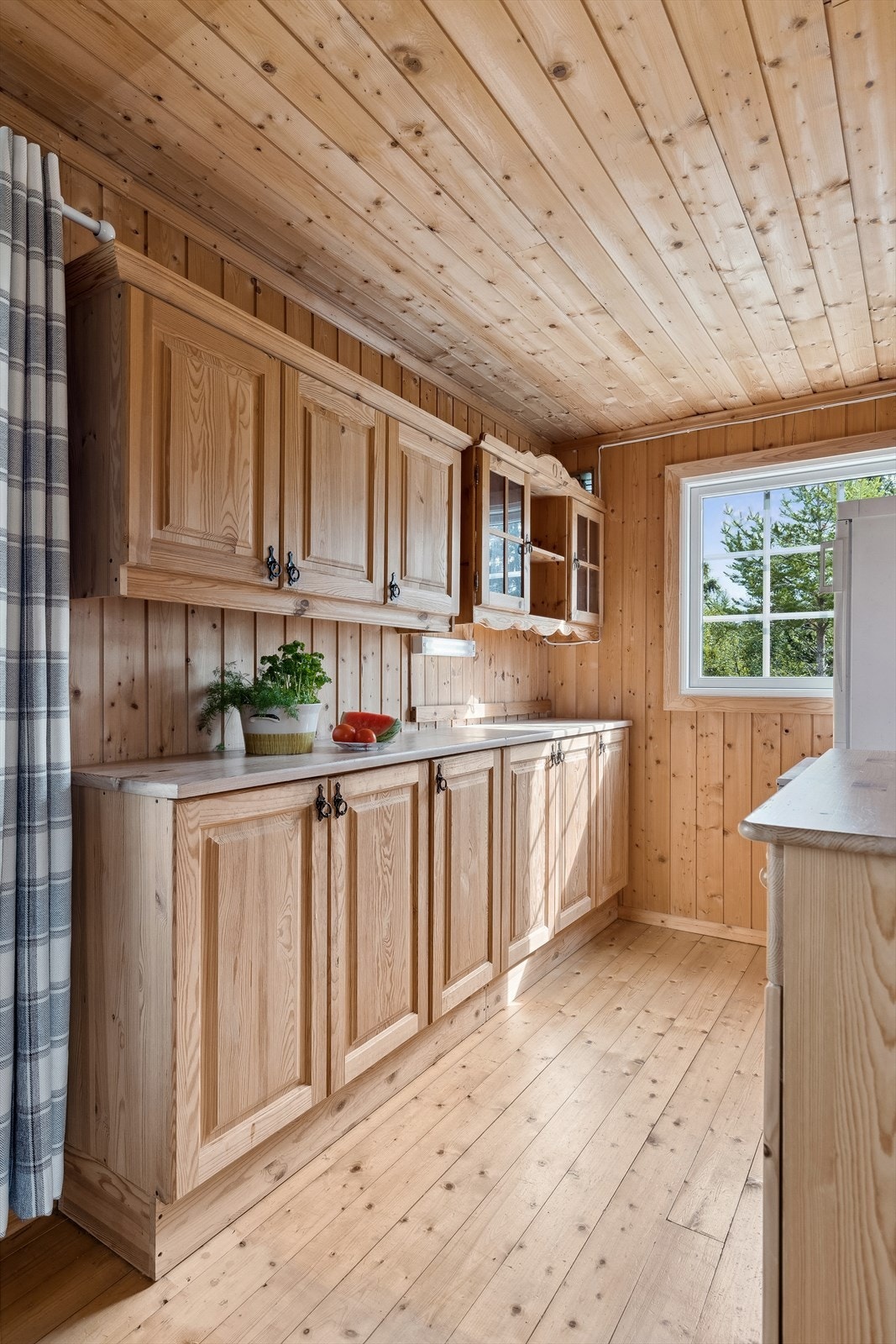 Det er en enkel heltre innredning fra byggeår. Godt med skap -og benkeplass. Frittstående komfyr og kjøleskap. Galleribilde