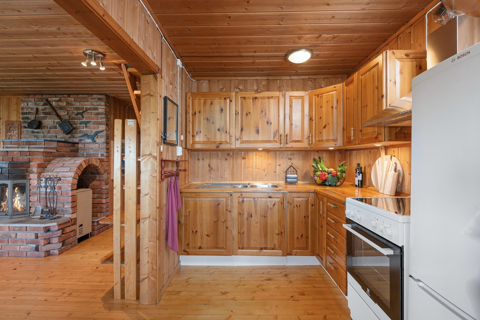 Kjøkkenet i den eldst delen har trehvite fronter med over-og underskap. Plass til komfyr og kjøleskap. Galleribilde