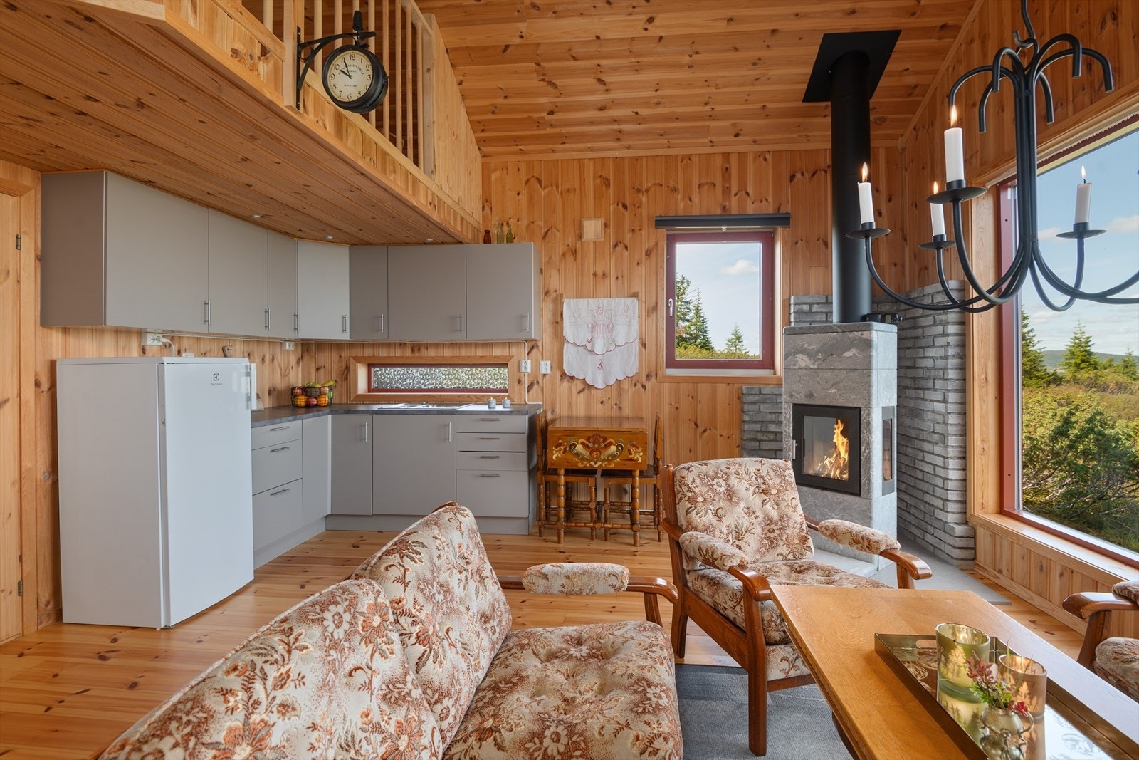 Moderne innredning på kjøkkenet med glatte fronter. Innredningen har en lun og delikat gråtone som står fint til de panelte veggene. Galleribilde