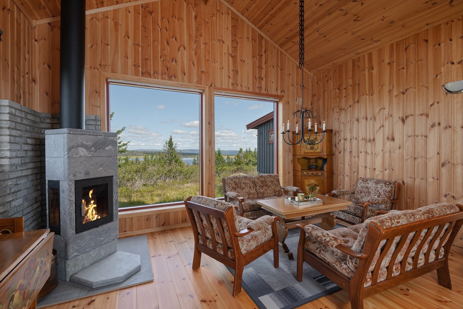 God oppvarming med en solid peisovn i kleber. Naturen kommer tett på gjennom vinduene. Galleribilde