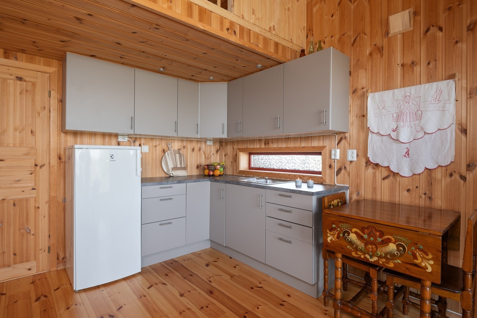 Pass til kjøleskap i forbindelse med kjøkkeninnredningen. Oppvaskkum i benk. Galleribilde