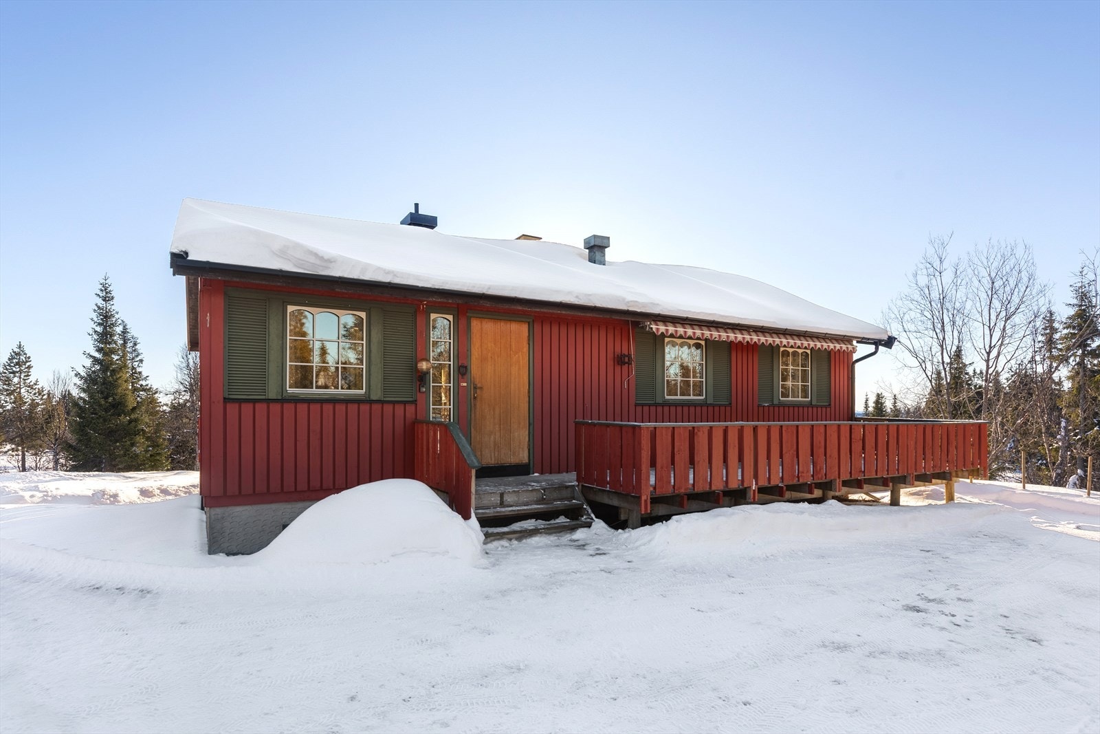 Den andre terrassen er i tilknytning til hyttas inngangsparti. Også denne terrassen har plass til utemøbler og det er montert en stor markise . Galleribilde