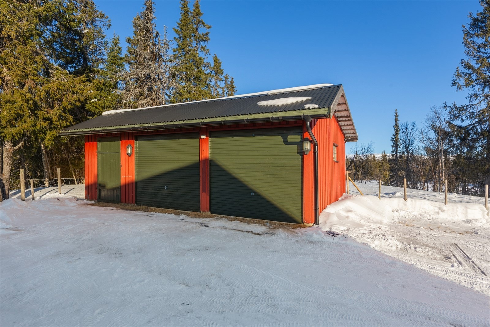 På tunet er det en praktisk garasje/uthus med to biloppstillingsplasser, noe lagerplass og vedskåle. Innvendig er det støpt betonggulv og bygget har innlagt strøm for belysning m.m. Galleribilde