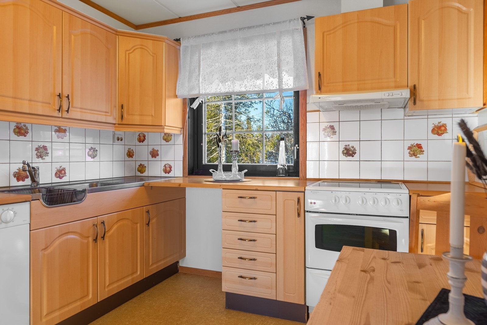 Kjøkkeninnredningen fikk nye profilerte fronter i 2006, og det er fliser på vegg mellom benk og overskap. Frittstående hvitevarer med komfyr, oppvaskmaskin og kjøl/fryseskap. Kjøkkenventilator med avtrekk ut. Galleribilde