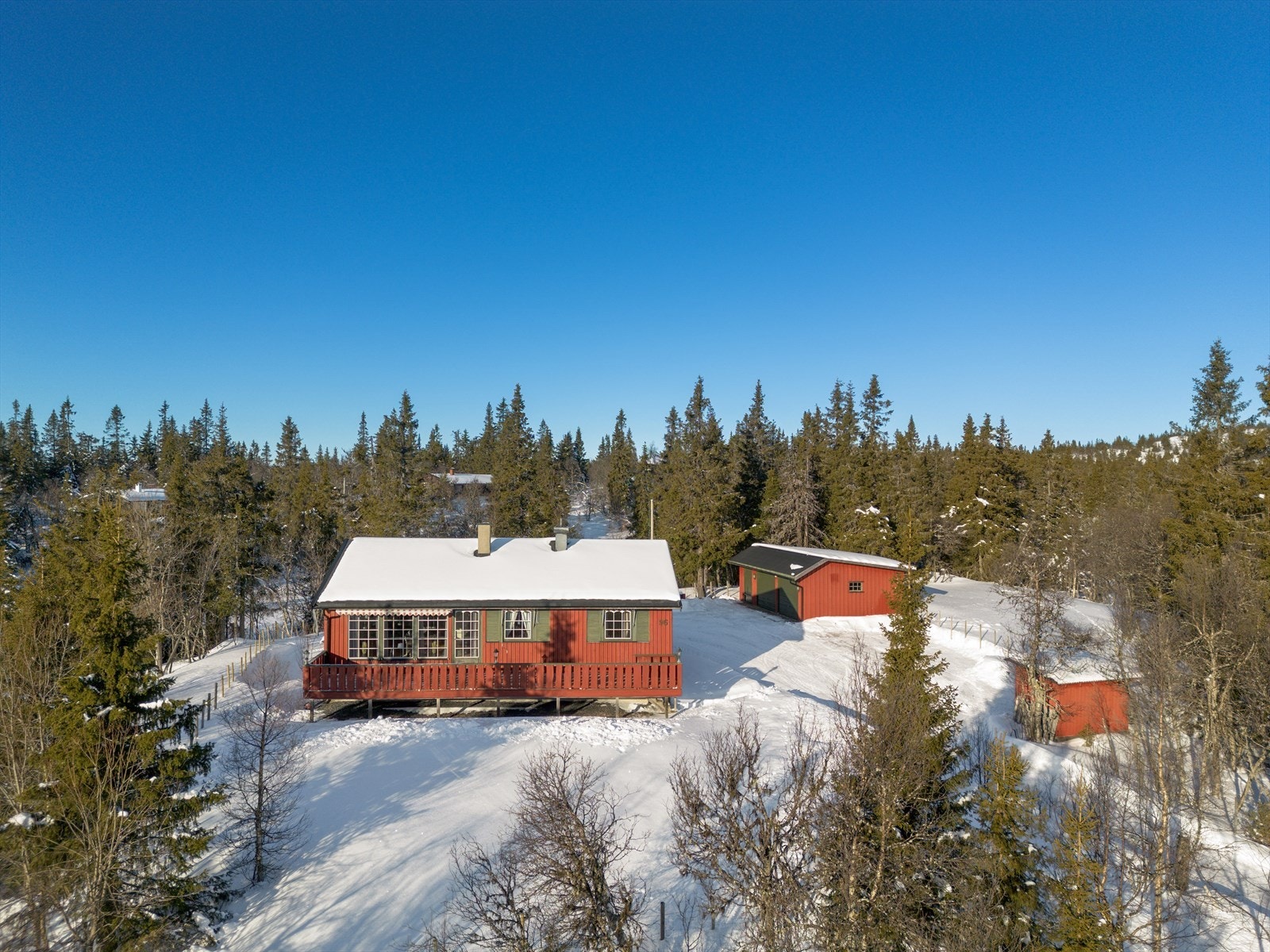 Her kan en nyte solen på usjenerte uteplasser, barna har god plass til å leke på, og med to biloppstillingsplasser i garasjen er en sikret snøfri bil ved hjemreise. Galleribilde