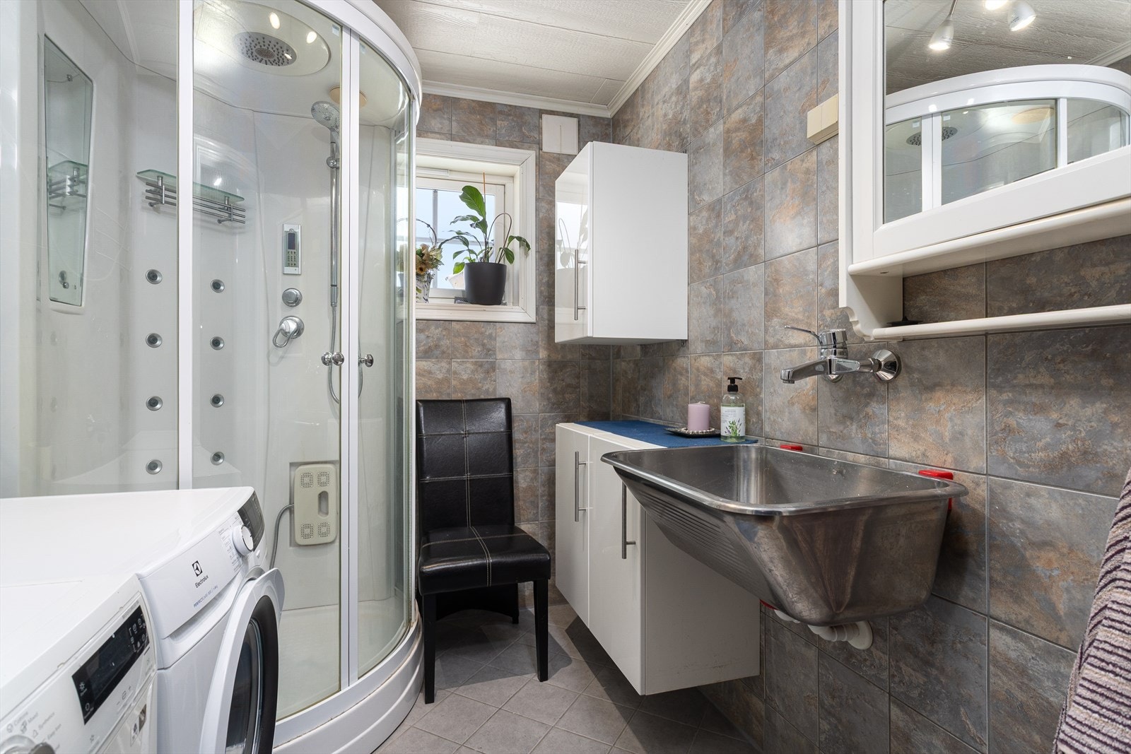 Vaskerommet er innredet med vaskekum, plass for vaskemaskiner og dusjkabinett. Galleribilde