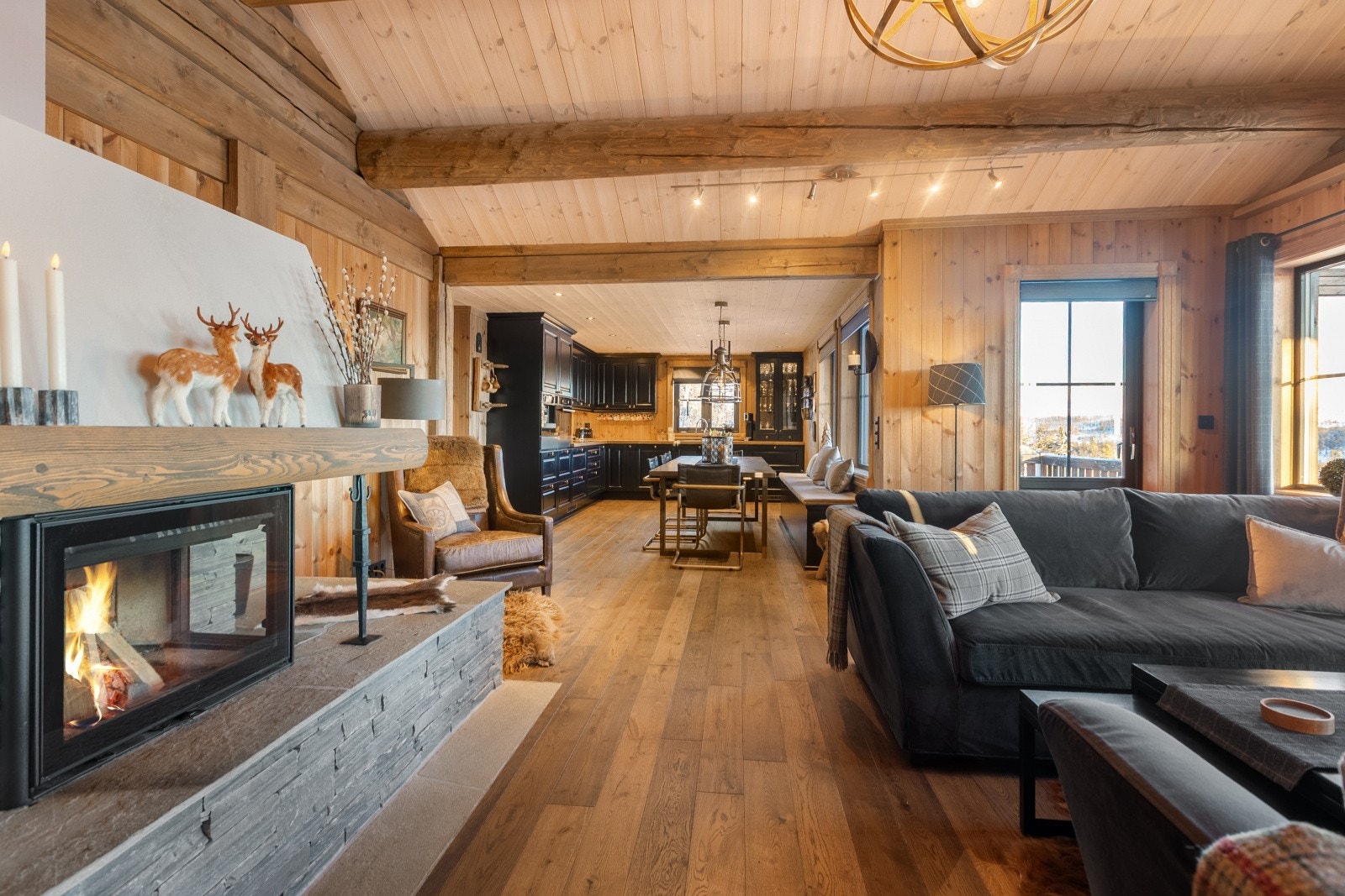 Stua har mye naturlig lys inn fra alle kanter via de store vinduene, og dette sammen med den rausta himlingen gir en god og luftig romfølelse. Galleribilde