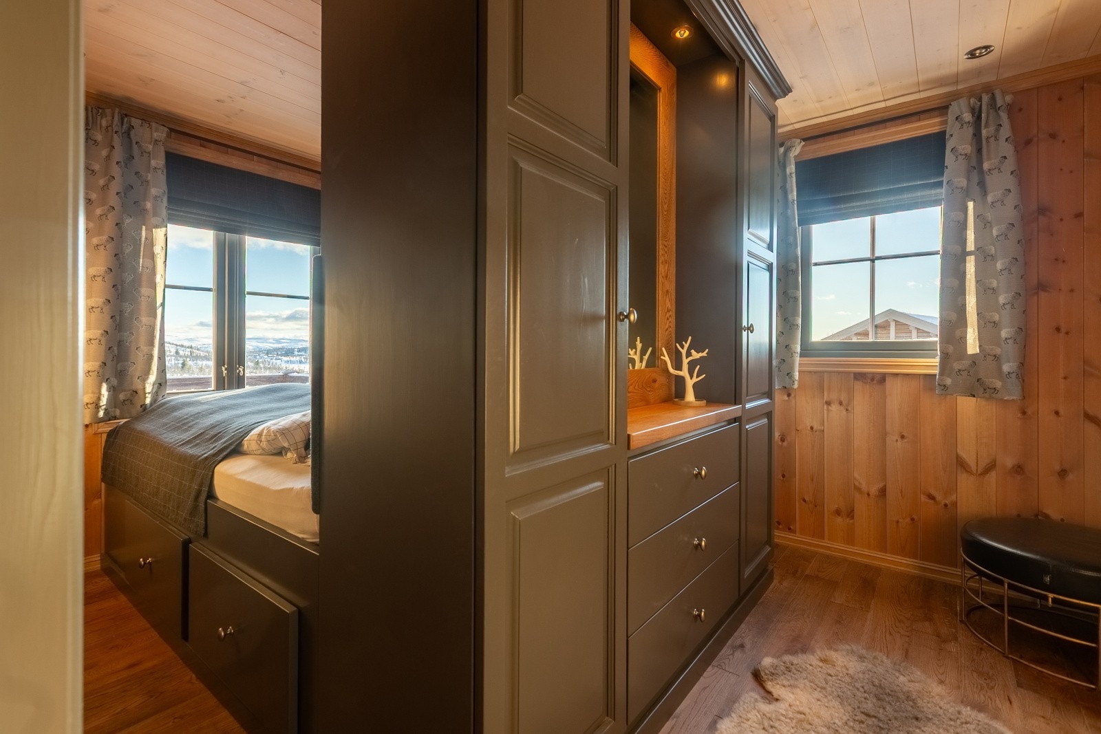 I hytta er det hele tre soverom, så her er det god plass til både store og små. Hovedsoverommet har dobbelseng av malt tre med skuffer og gavl med hylle. Galleribilde