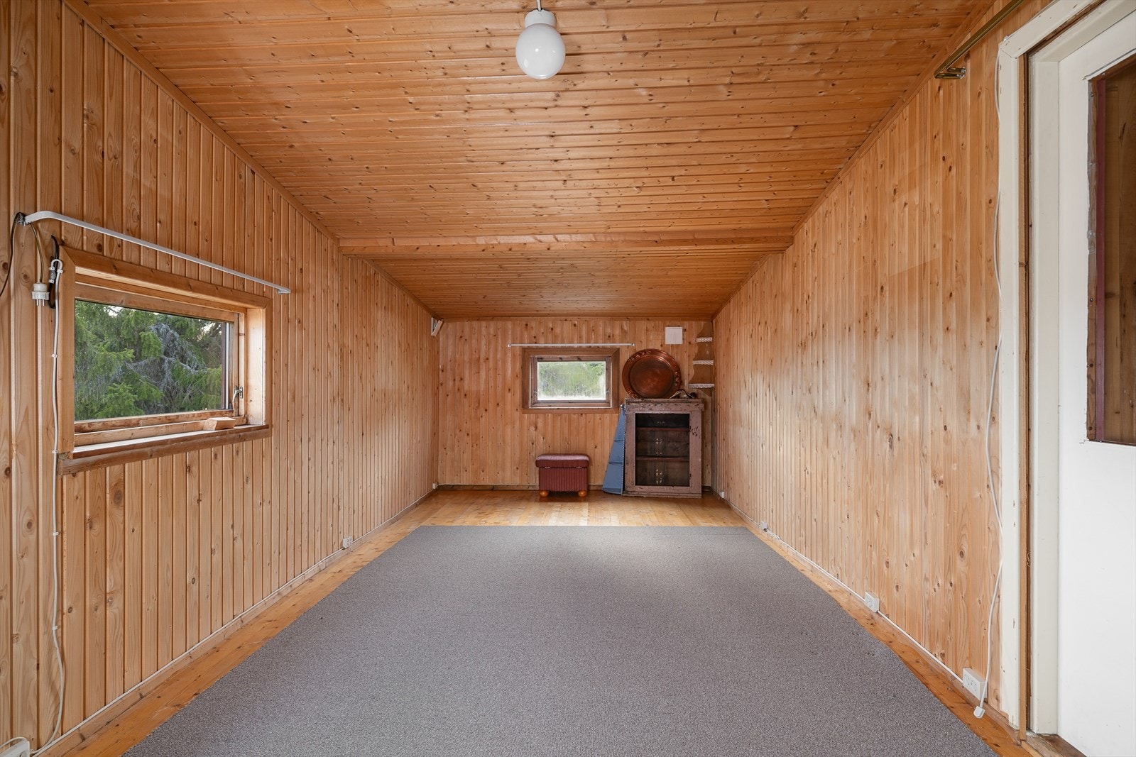 Stue med fint lys inn fra vinduer på to vegger. Galleribilde