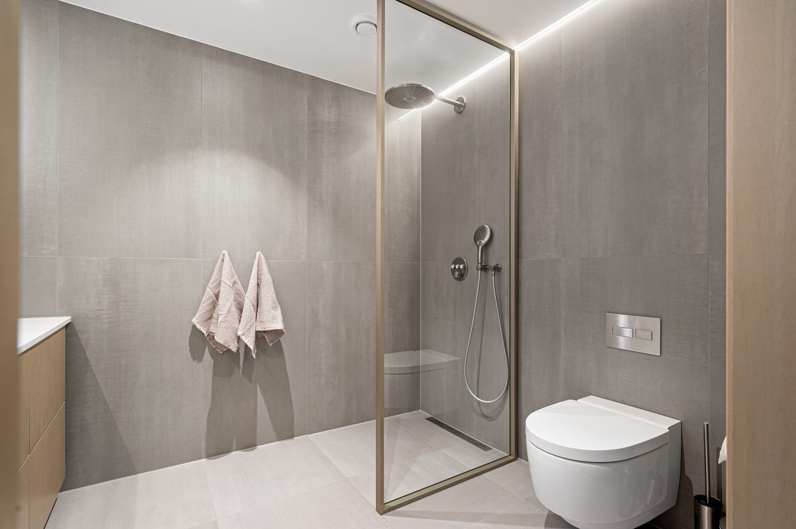 Vegghengt toalett og delikat dusjsone med regndusj. Galleribilde