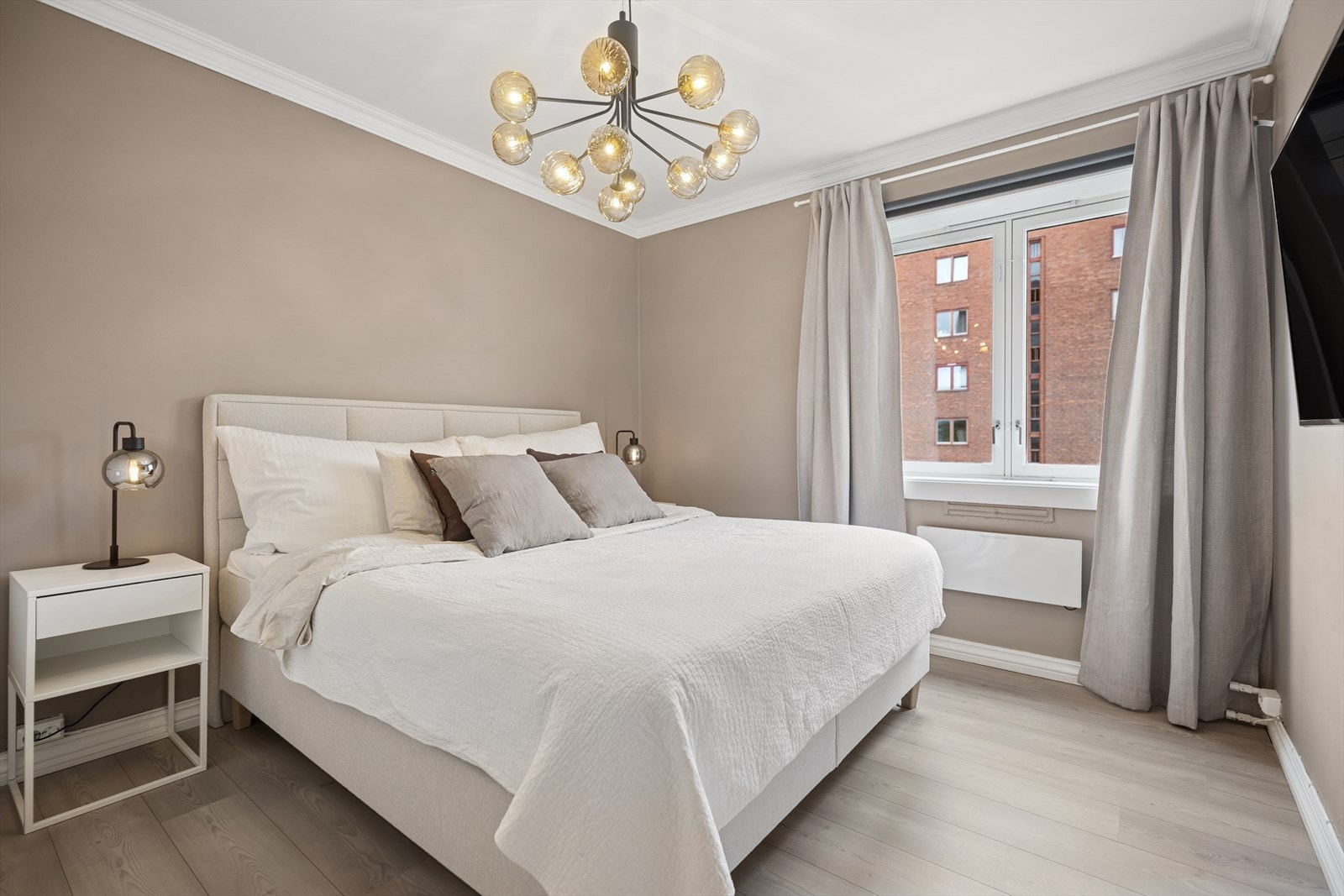 Romslig soverom med plass til dobbeltseng og nattbord på hver side. Rommet er malt i behagelige farger. Galleribilde