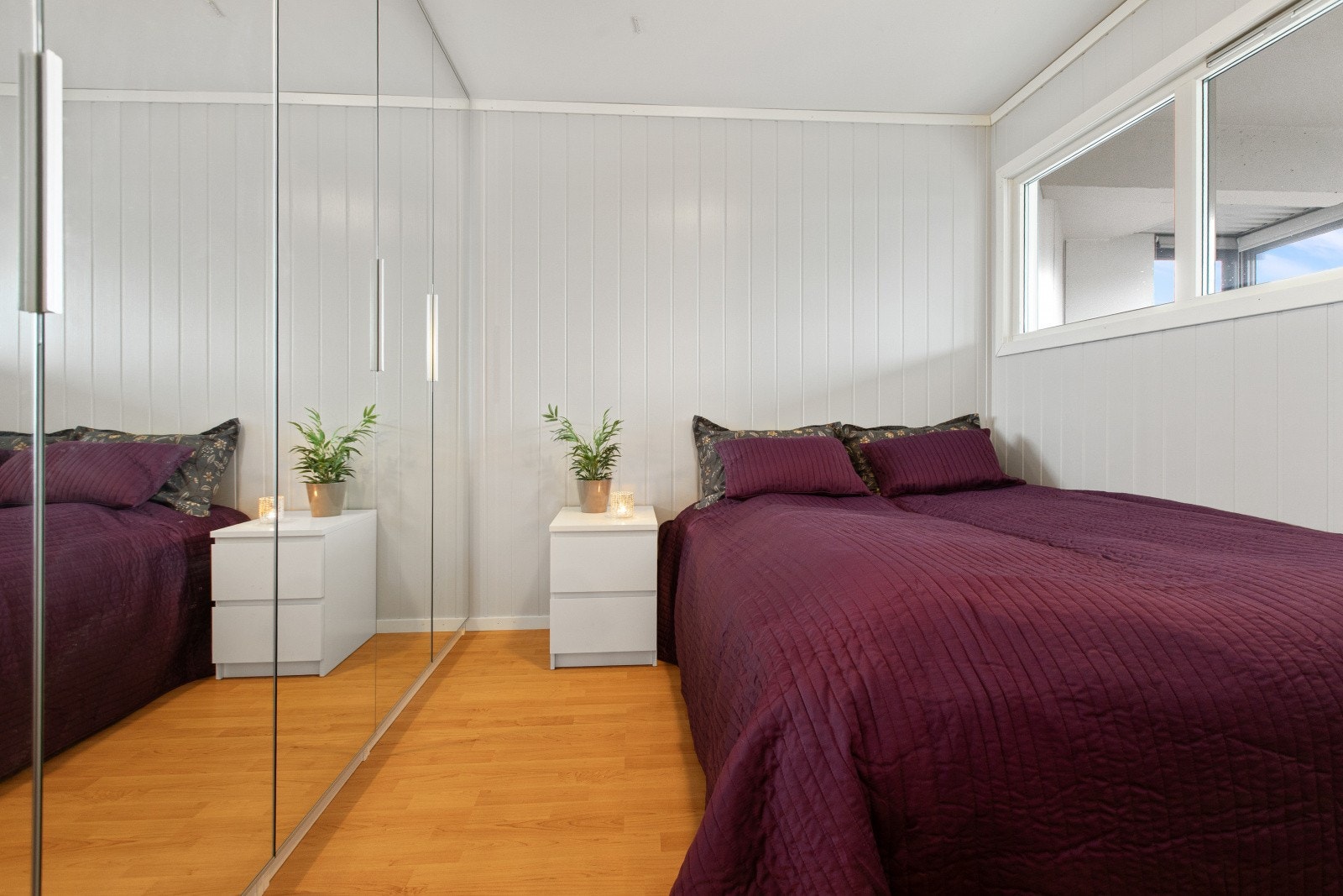 Stor garderobeløsning med speilfronter gir effektiv oppbevaring og utnytter soverommet godt. Galleribilde