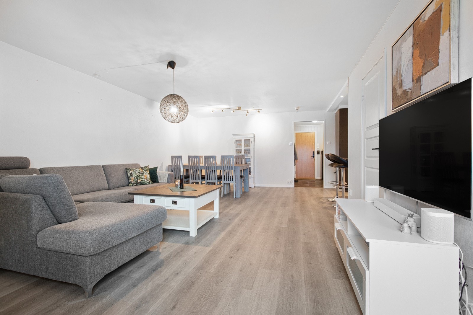 Delvis åpen løsning mellom stue og kjøkken gir en praktisk og sosial sone. Galleribilde