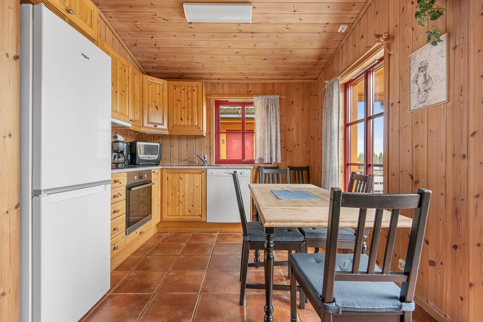 Kjøkken har trehvit innredning med integrert komfyr og oppvaskmaskin. Plass til kjøl/frys. Galleribilde