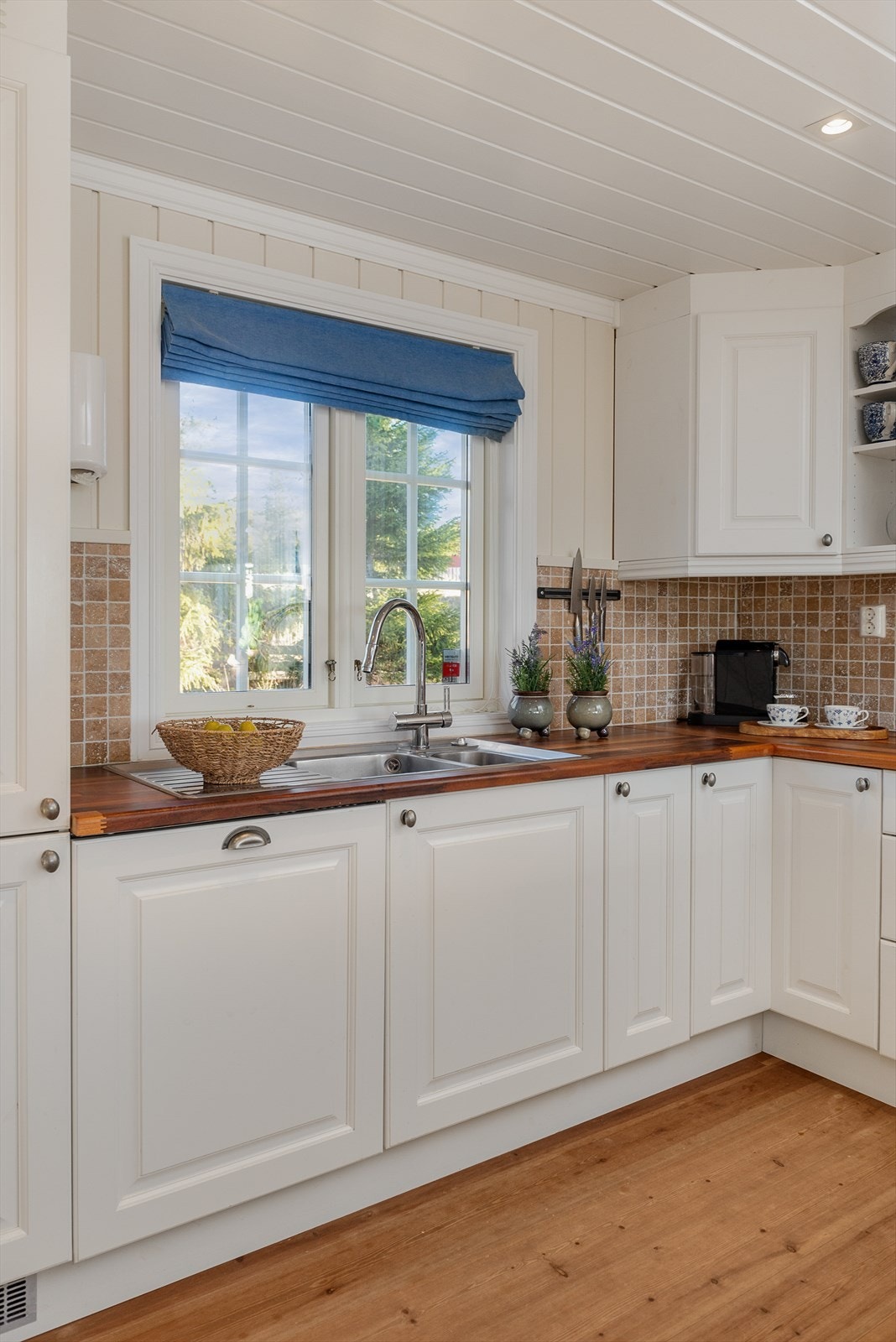 Det er fliser over benk som står fint til kjøkkenbenken. Gjennomført og helhetlig. Galleribilde