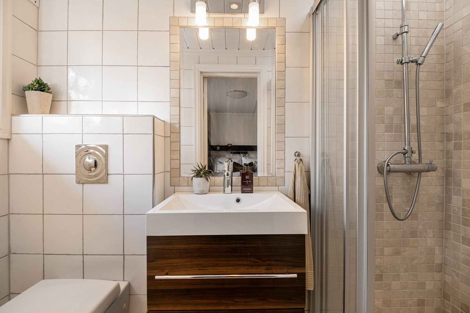 Bad 2 har direkte adkomst fra hovedsoverommet. Tidløst og delikat, med flislagt dusjhjørne, servantinnredning og vegghengt WC. Galleribilde