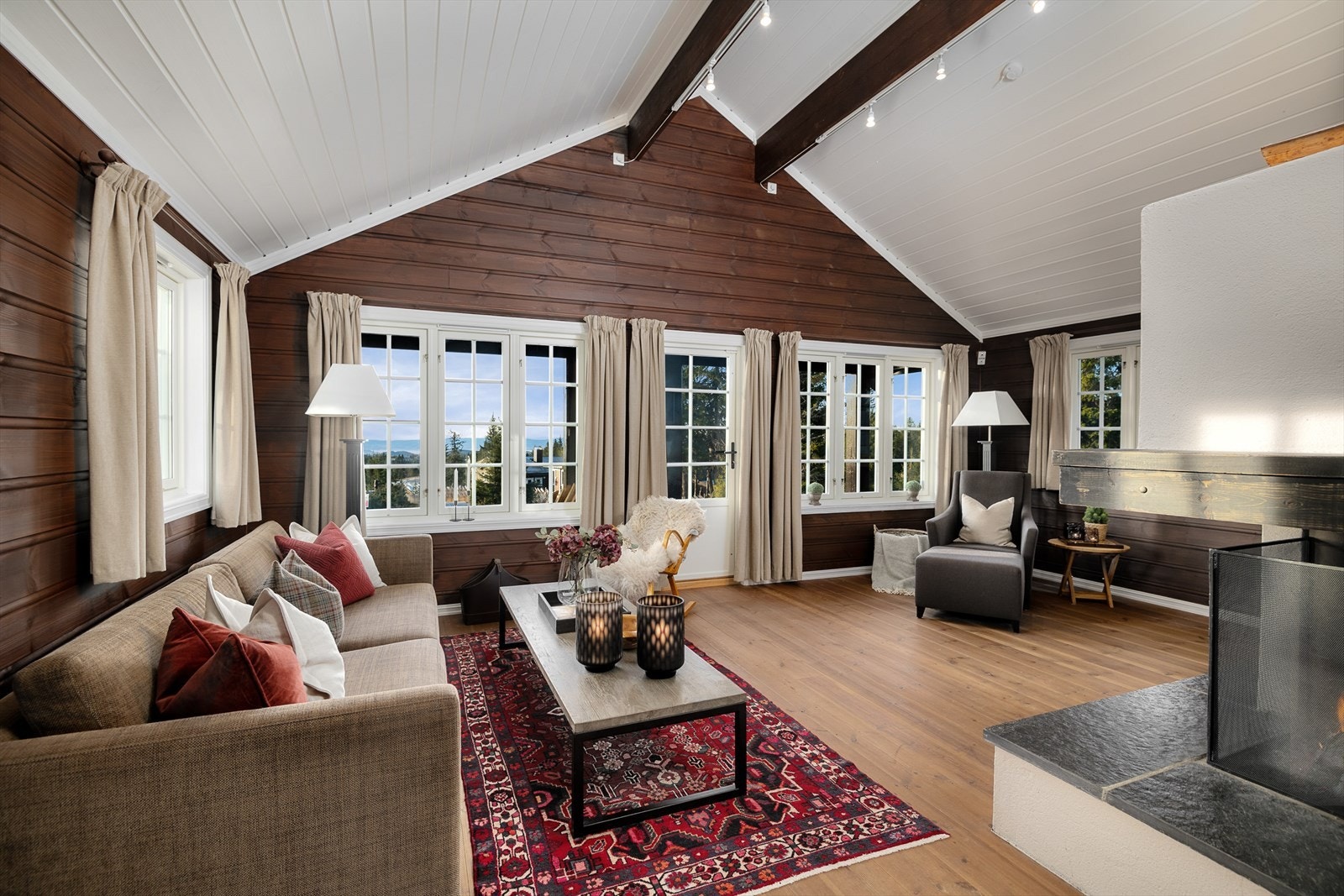 Det er en romslig og koselig stue i hytta med god takhøyde og rikelig med naturlig lys inn gjennom store vindusflater på 3 vegger. Galleribilde