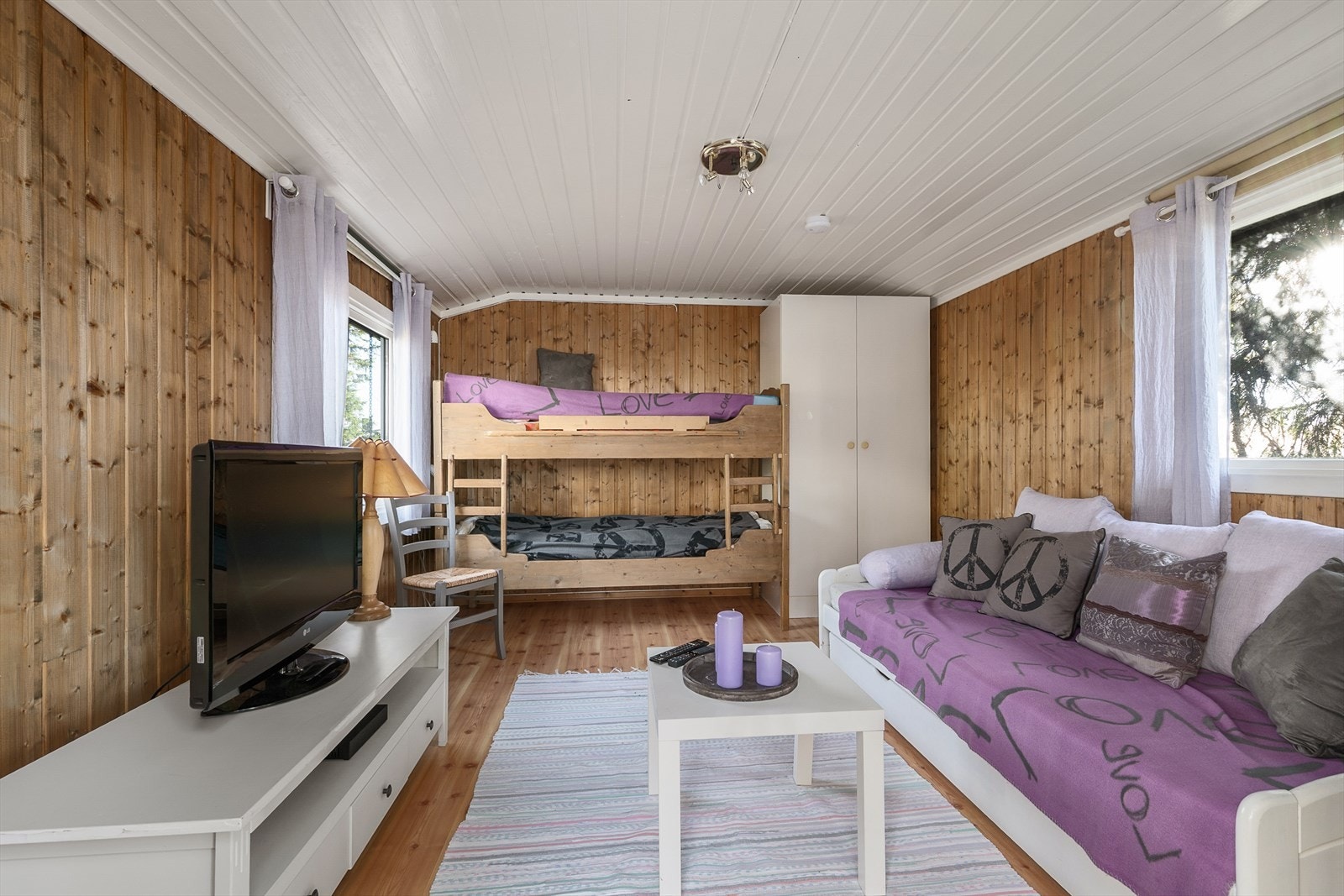 Anneks innredet som stue/gjesterom. Veggene har beiset panel. Lakkerte tregulv. Galleribilde