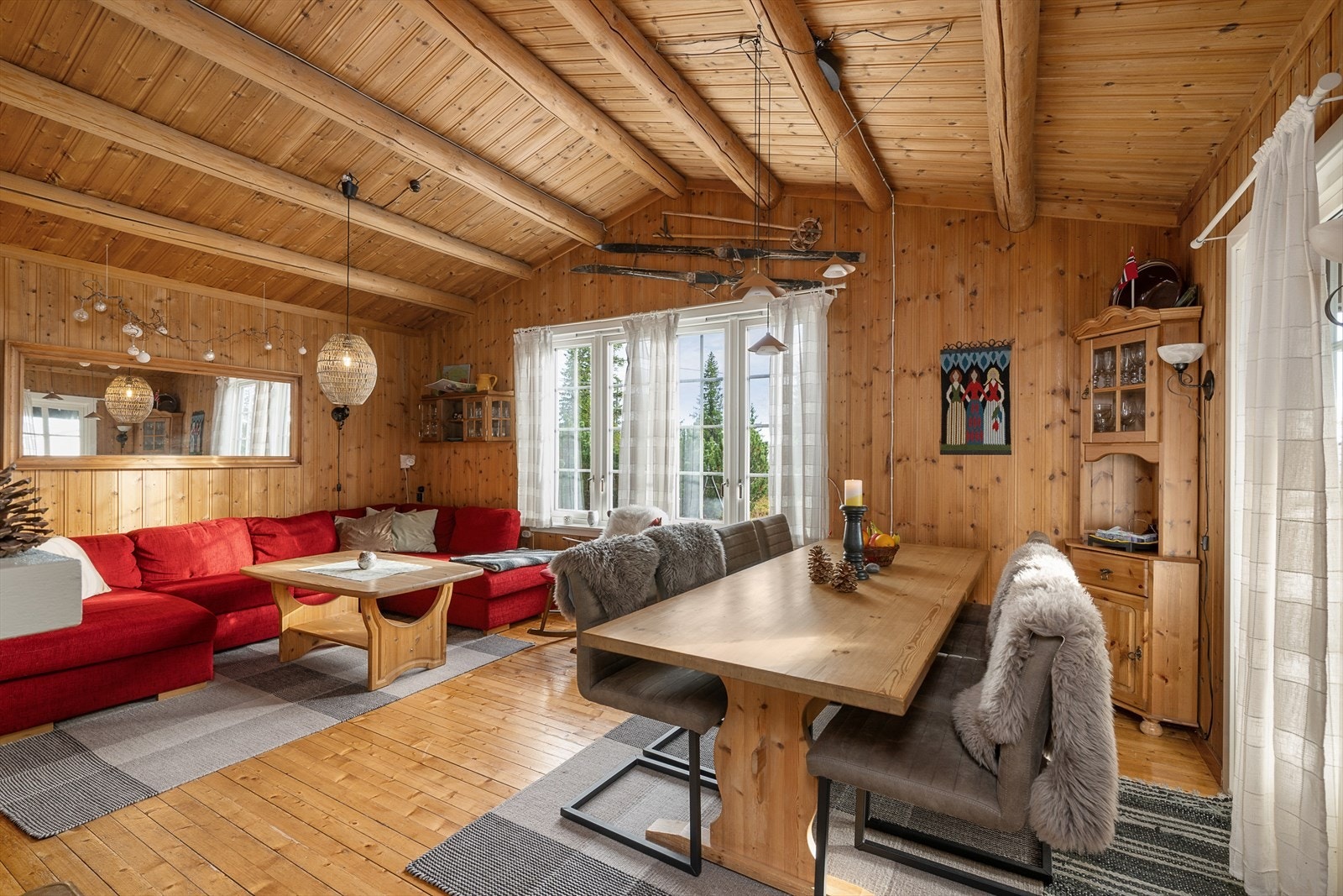 Det er en tradisjonell stil i stua med tregulv og panelte vegger/tak. Galleribilde