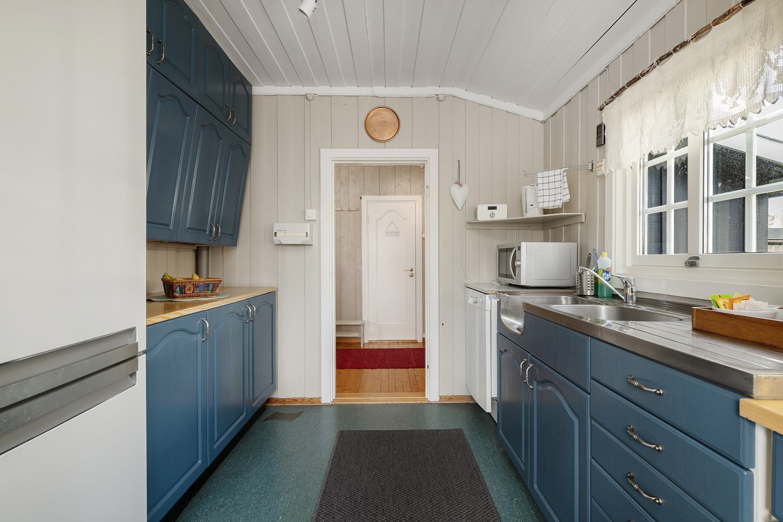 Kjøkkeninnredningen er har blåmalte fronter. Lett profilering på skapene. Galleribilde