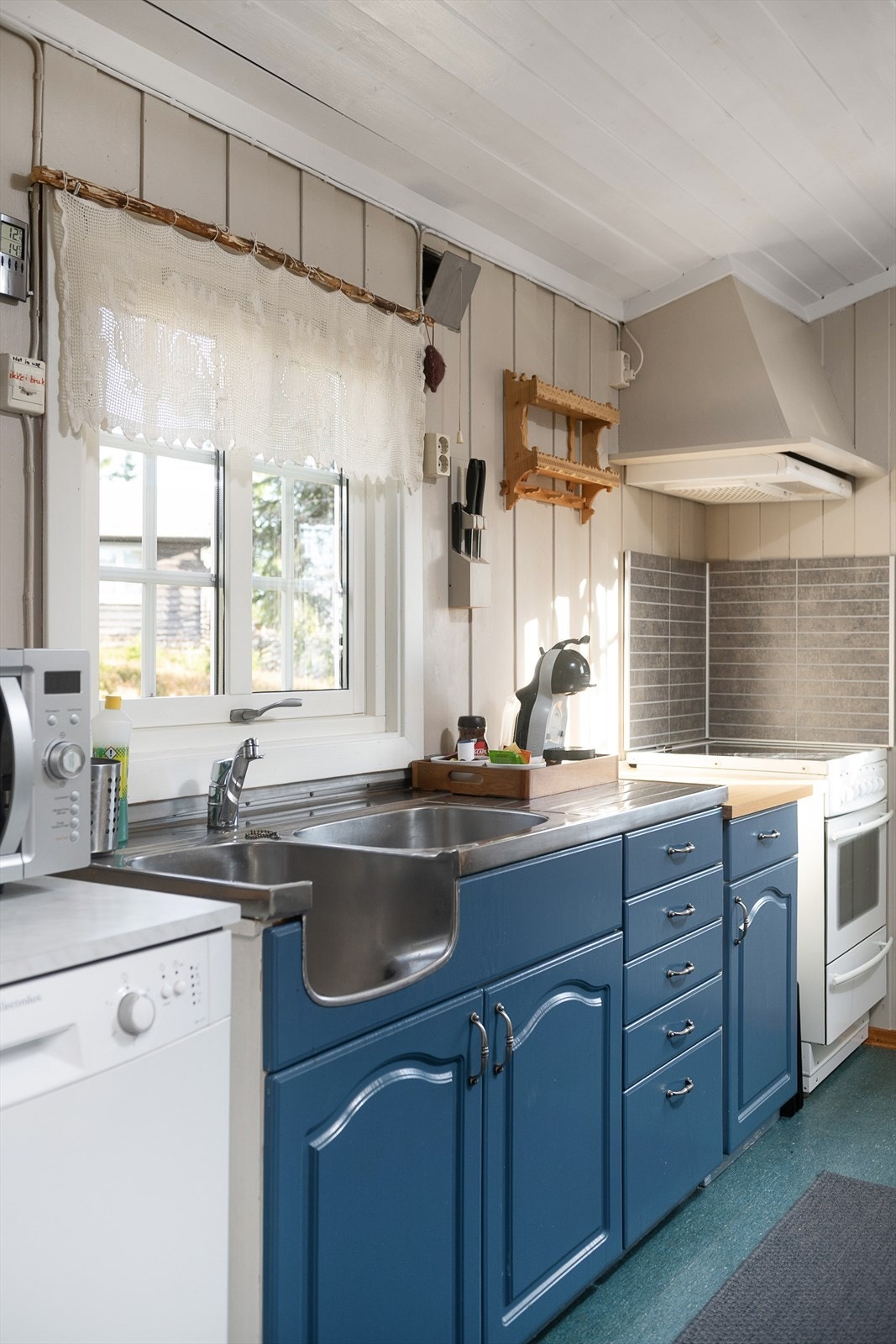 Det er plass til komfyr, oppvaskmaskin og kjøleskap på kjøkkenet. Malt panel på veggene. Belegg på gulv. Galleribilde