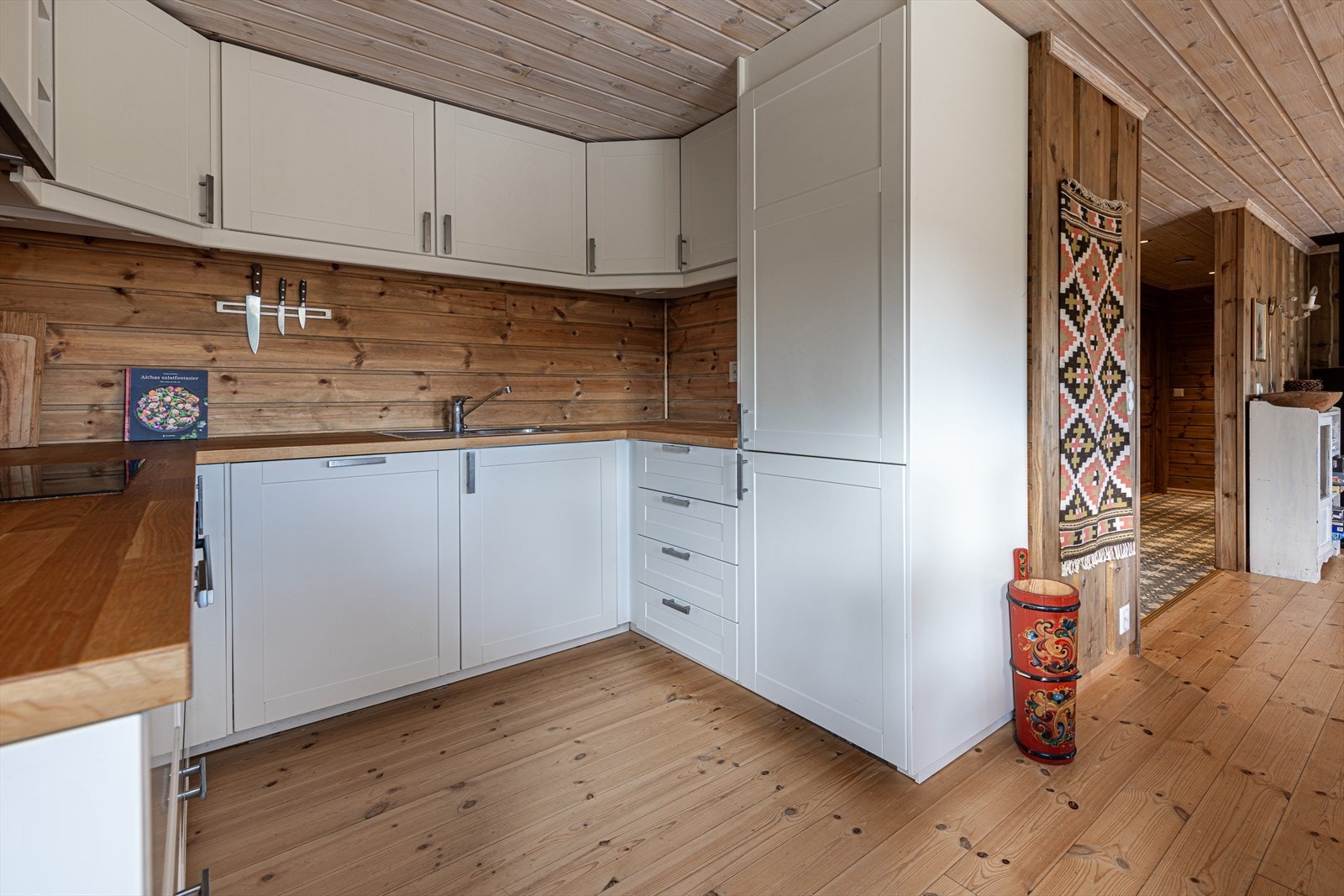 Stilrent og funksjonelt kjøkken med rikelig oppbevaringsplass i benker og skap Galleribilde