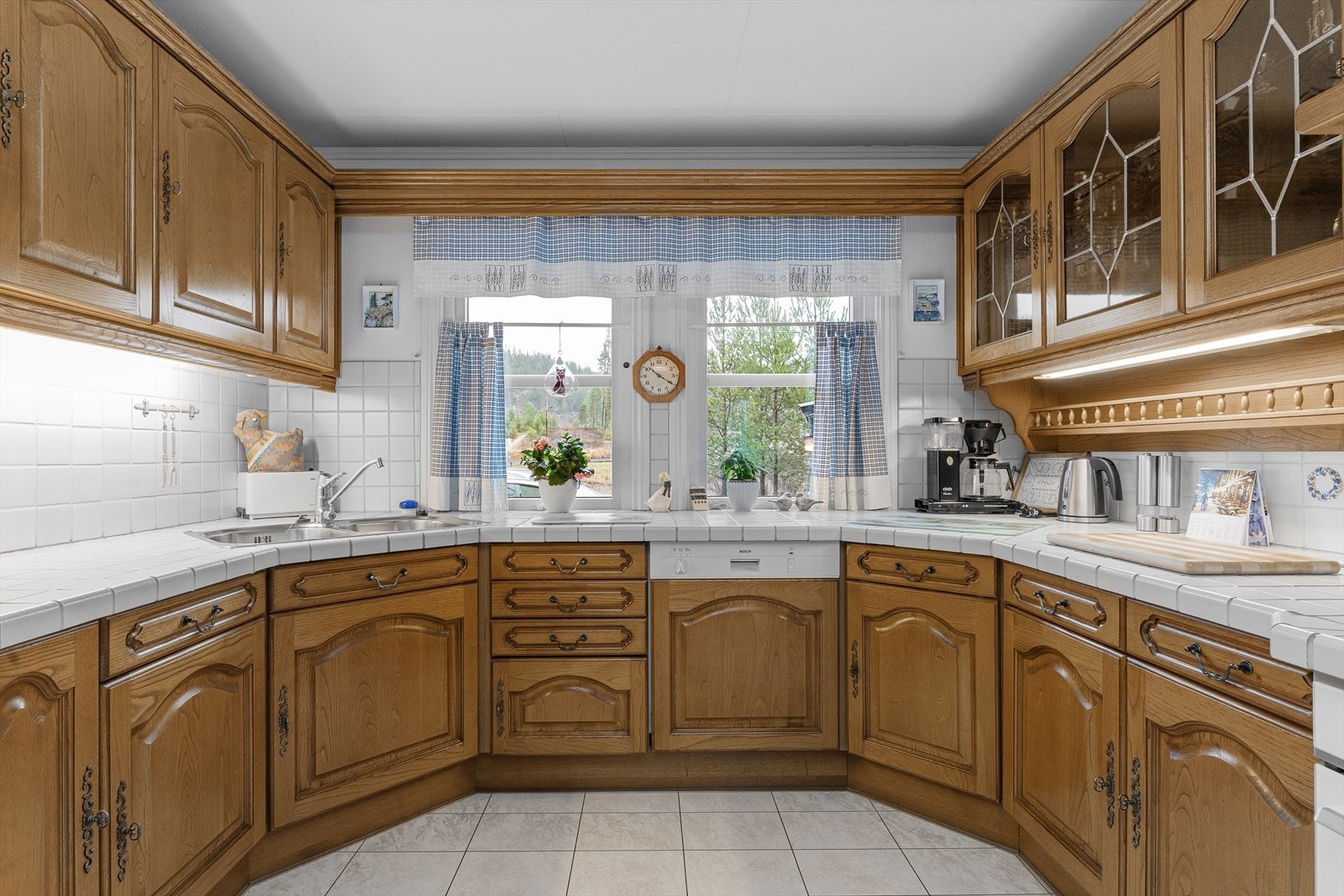 Profilert kjøkkeninnredning og flislagt benkeplate. Galleribilde