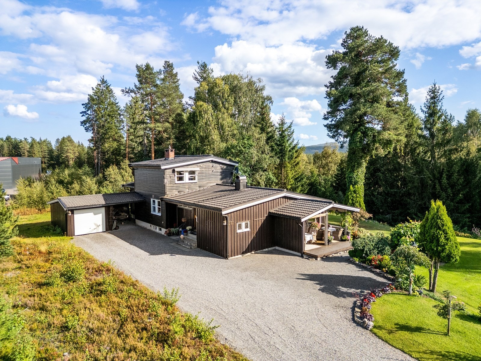 Gruset adkomst og gårdsplass. Takoverbygd inngangsparti. Galleribilde