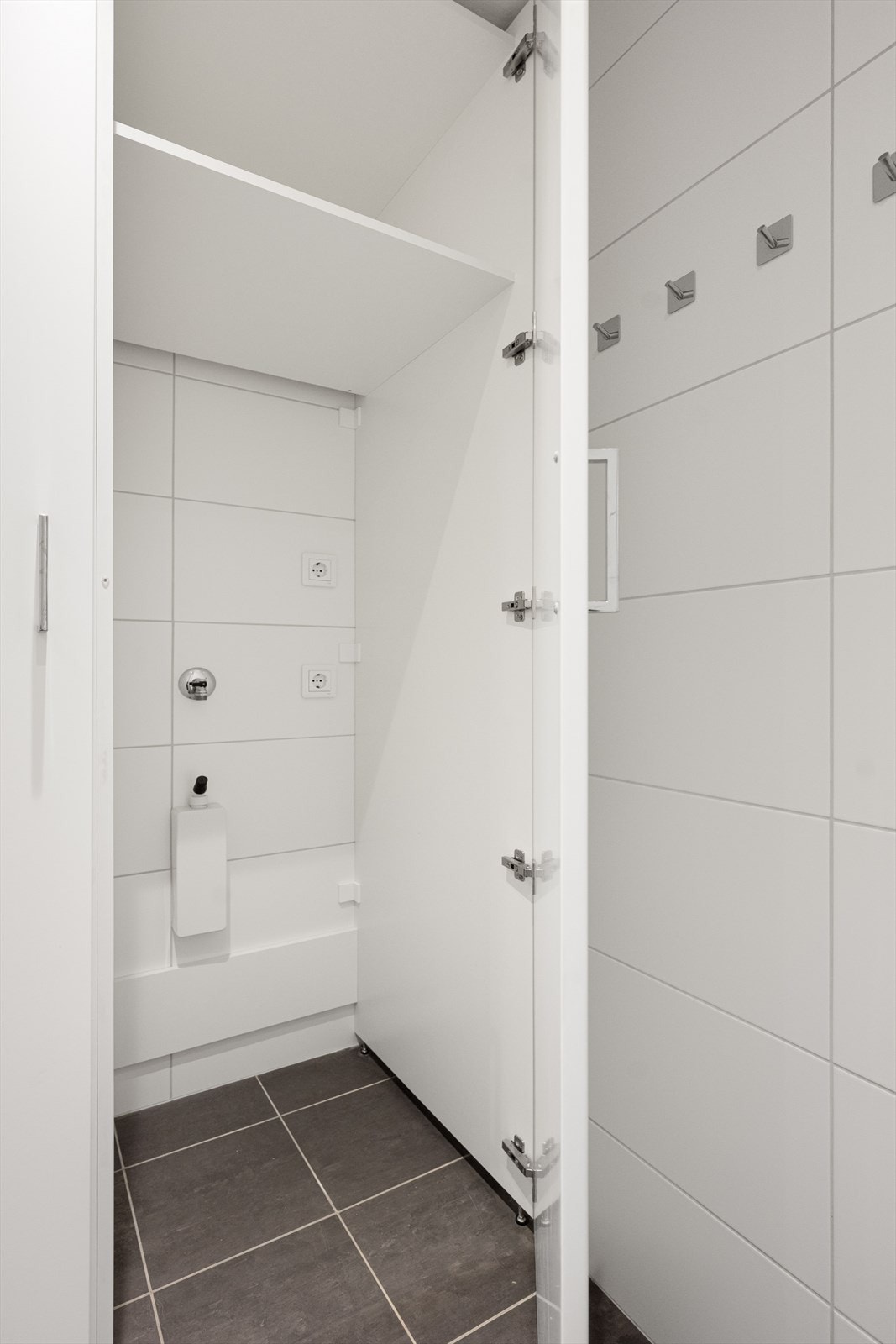 Badet har opplegg for vaskemaskin og tørketrommel som behagelig kan plasseres i skap. Galleribilde