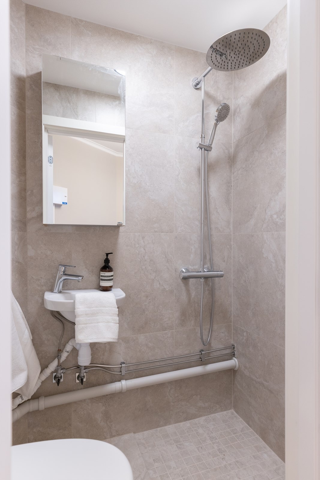 Det er overflateoppusset med ny smøremembran, varmekabler, belysning og innredning over eksisterende bad. Galleribilde