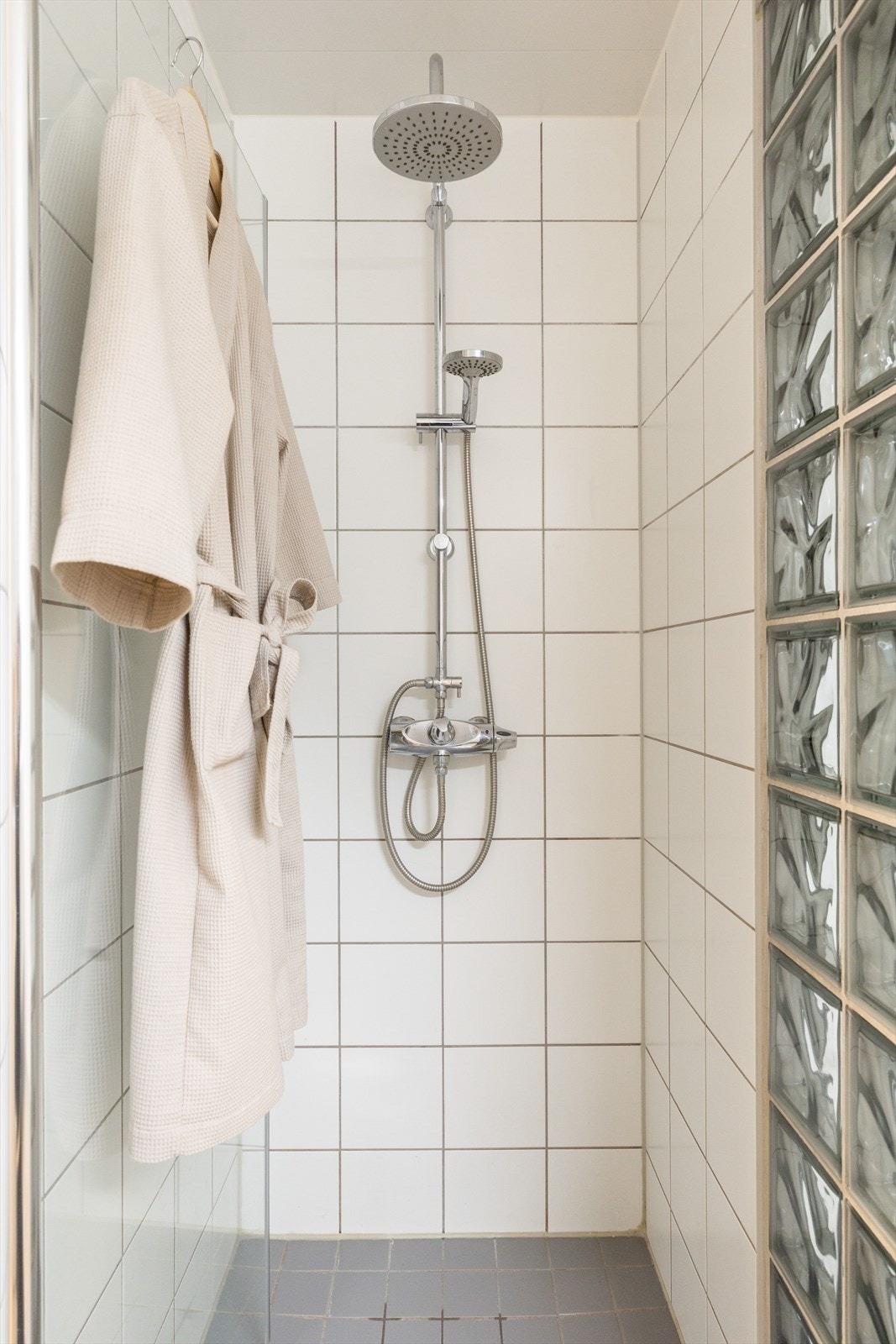 Badet er innredet med vegghengt klosett, servant nedfelt i innredning, speilskap og dusjhjørne med svingbar glassdør. Galleribilde